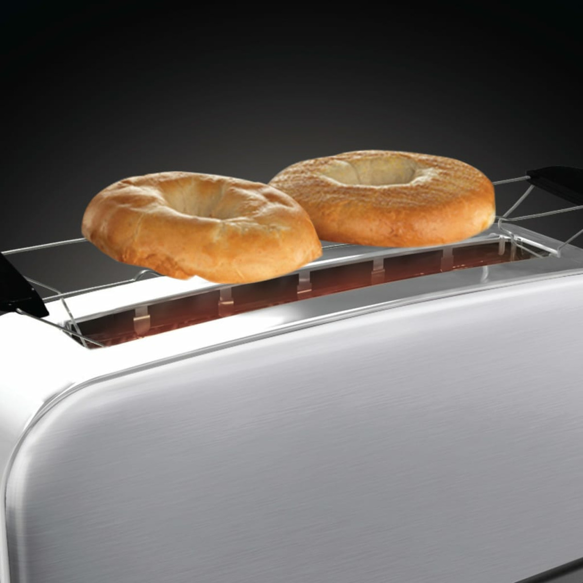 Dwa tosty z bajglem na srebrnym tosterze.