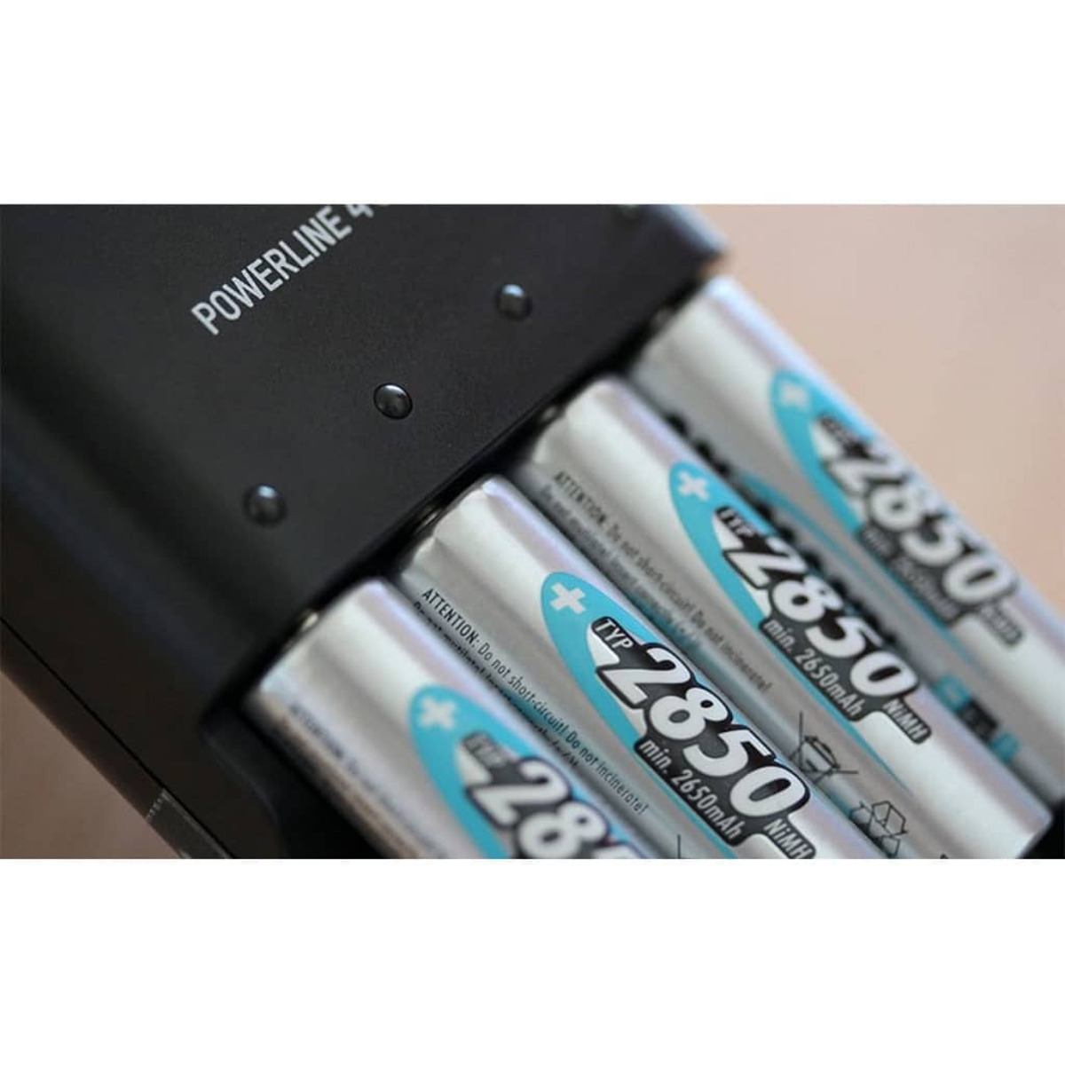 Nahaufnahme eines Batterieladegeräts mit vier silber-blauen AA-Akkus.