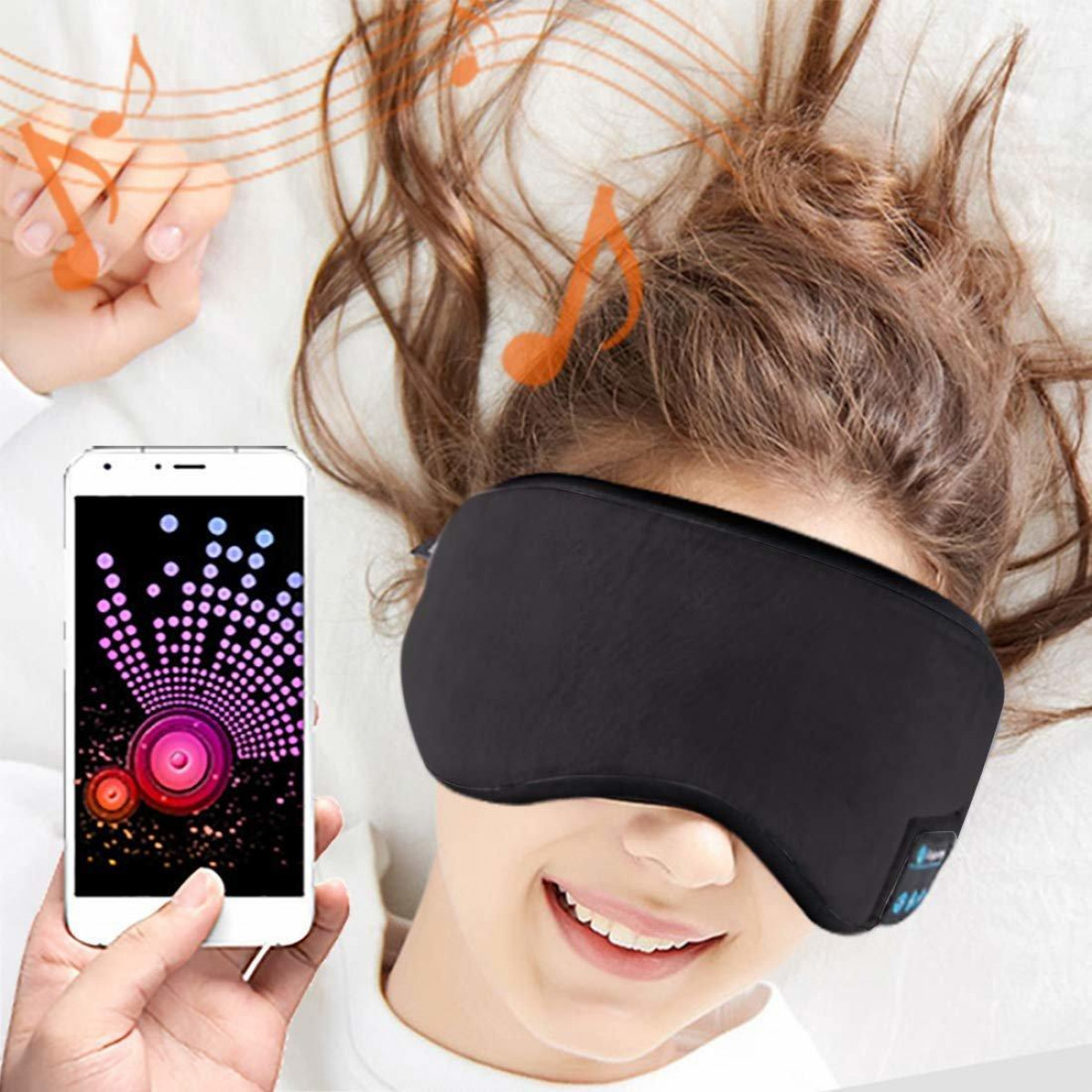 Kobieta w czarnej masce do spania, z telefonem pokazującym wyświetlacz muzyczny i nuty.