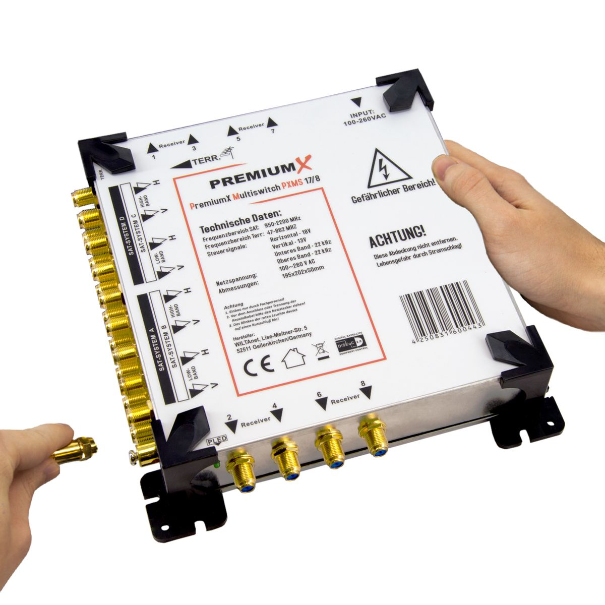 Ein weißes und schwarzes elektrisches Gerät mit goldenen Anschlüssen, eine Hand hält einen Stecker.