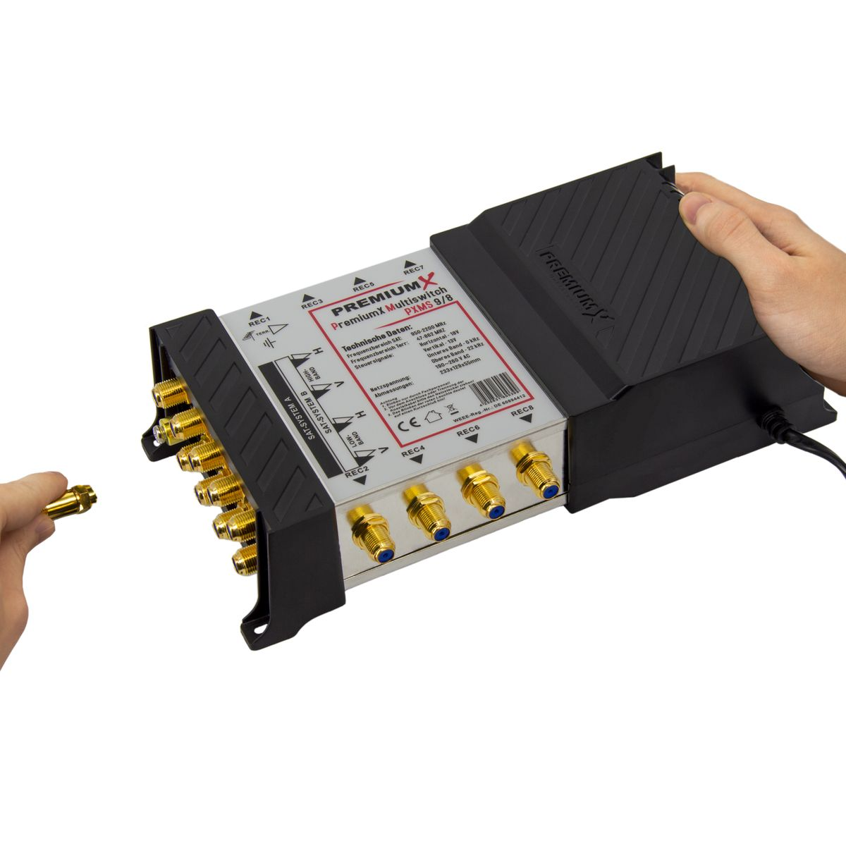 Nahaufnahme eines schwarzen elektronischen Geräts mit goldenen Anschlüssen, Hand hält Stecker.