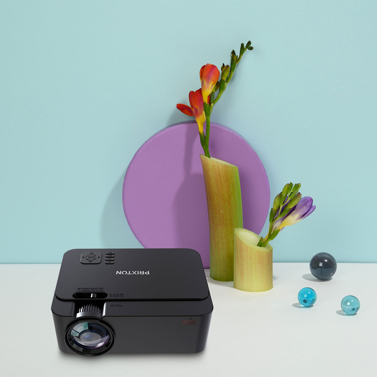 Czarny projektor z kwiatami i kulami dekoracyjnymi.