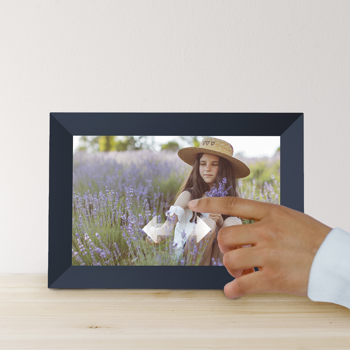 Oprawione zdjęcie przedstawia dziewczynę na polu fioletowych kwiatów; ręka dotyka ramki.