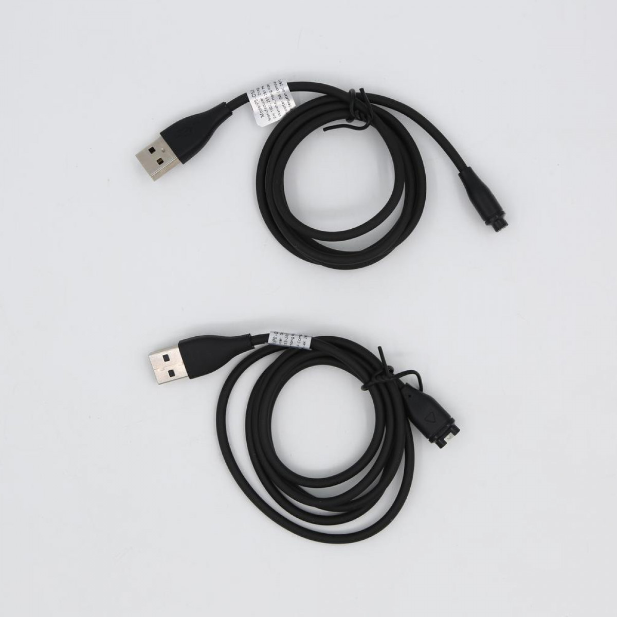 Dwa czarne kable do ładowania USB, każdy z USB-A i unikalnym złączem na białym tle.