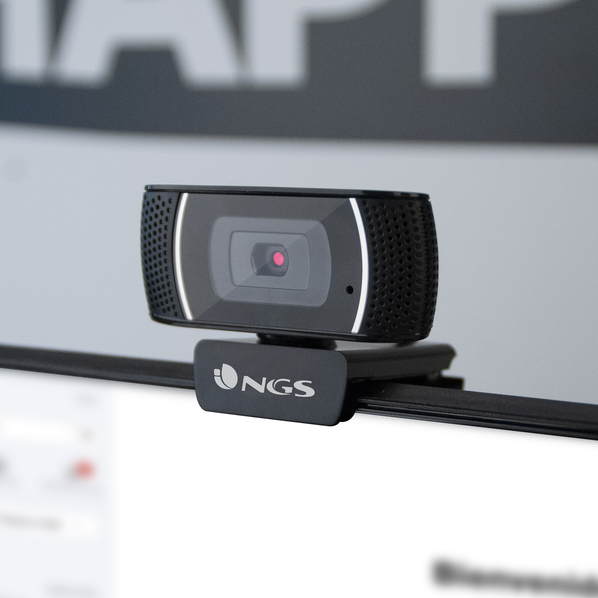 Una webcam nera è montata su una barra nera con uno sfondo bianco, la webcam ha una luce rossa al centro.