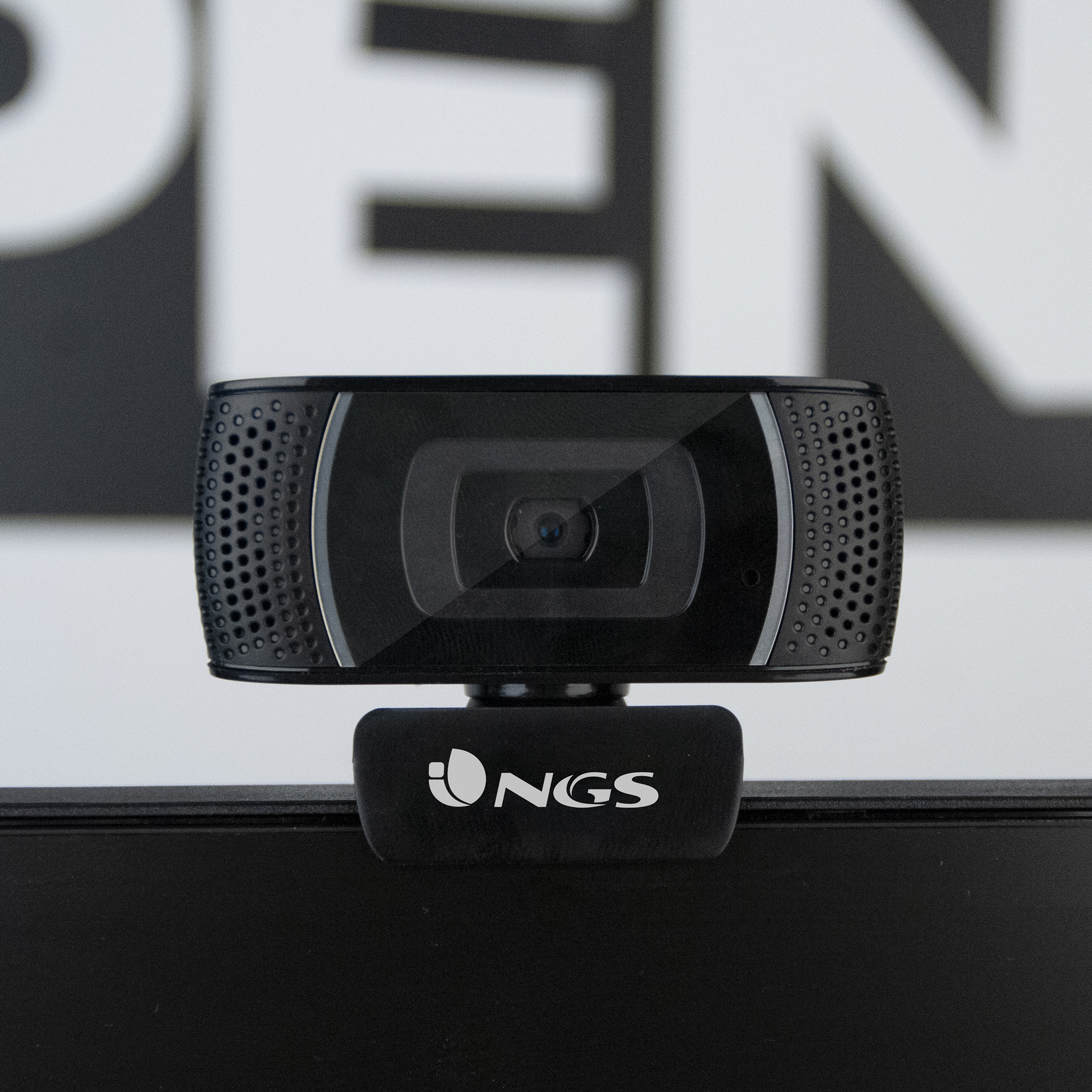 Una webcam nera con il logo NGS, di fronte a un cartello APERTO sfocato.
