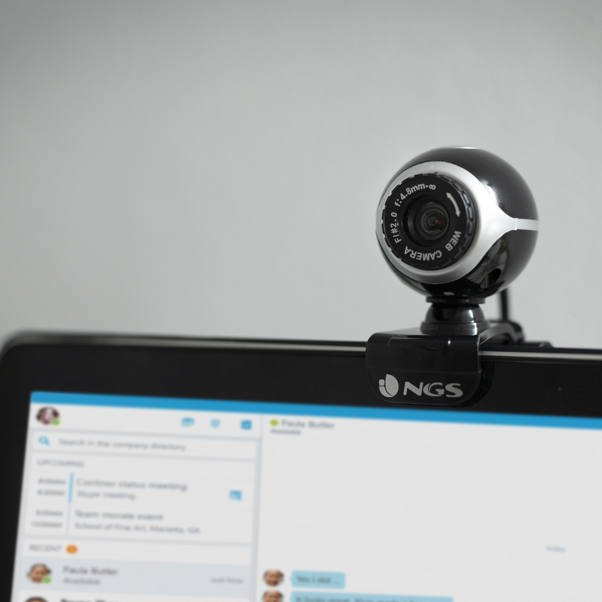Eine schwarz-silberne Webcam oben auf einem Computermonitor, der einen Videoanrufbildschirm anzeigt.