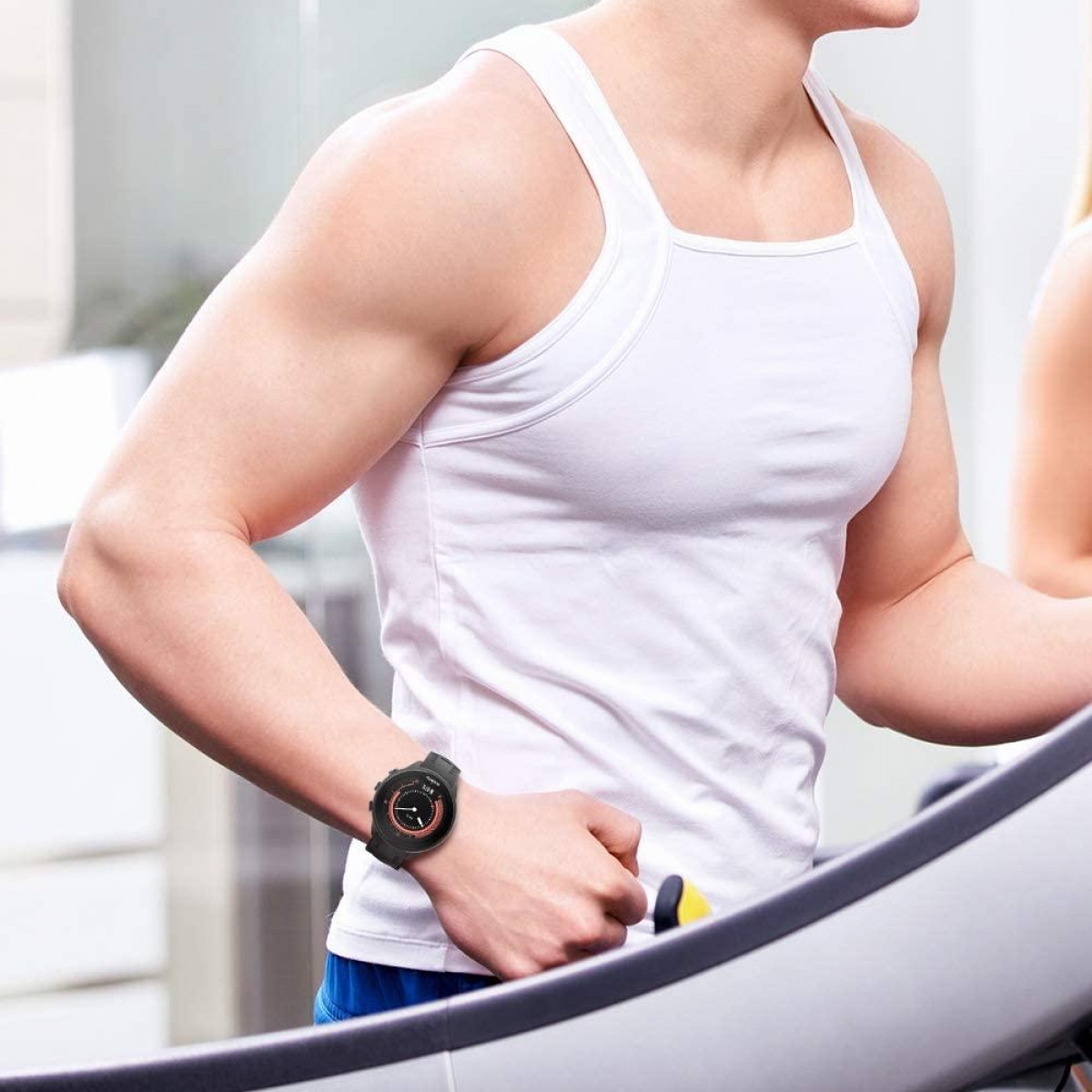 Homme sur un tapis roulant avec une montre de fitness. Dans une salle de sport. Son bras est fléchi.