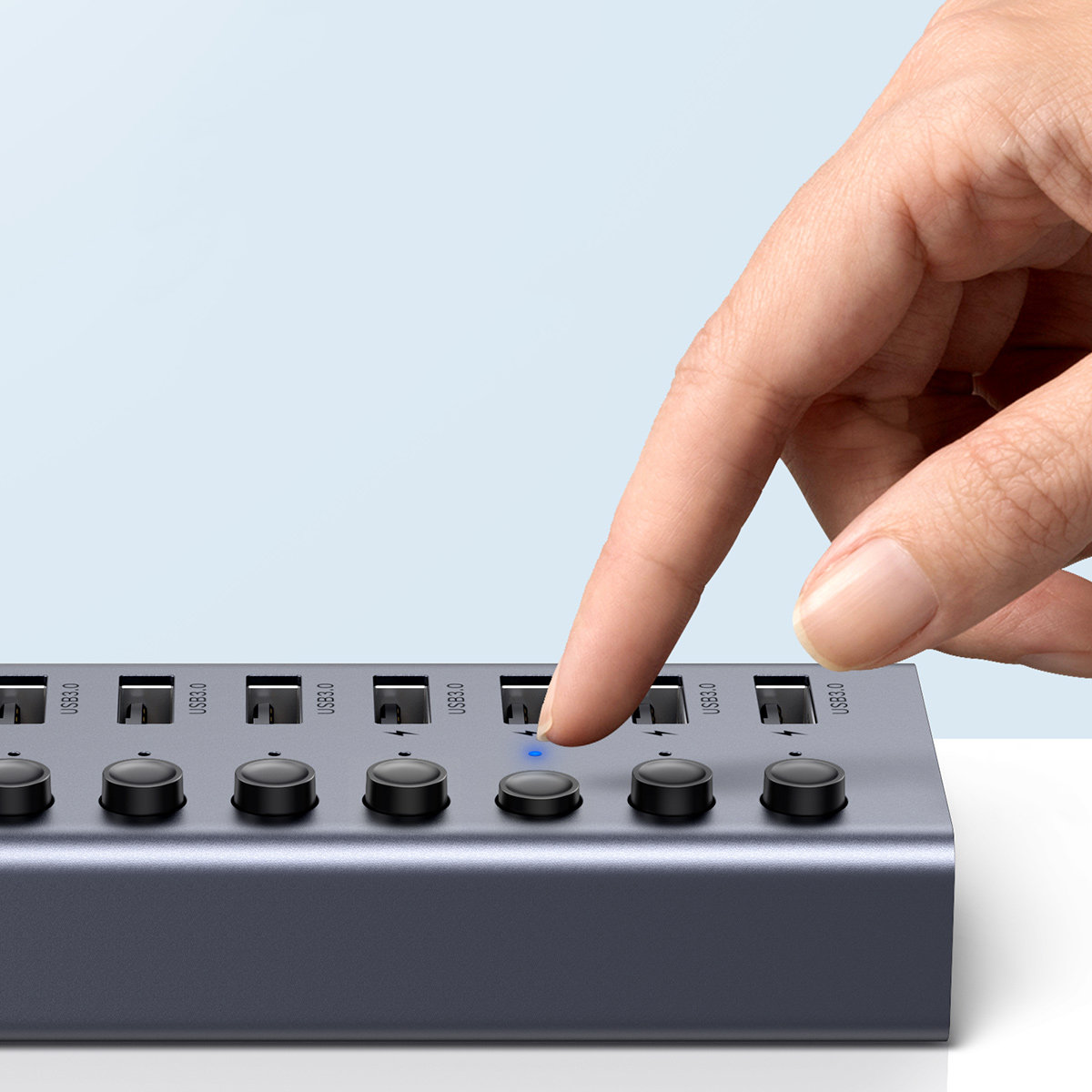 Ręka dotykająca koncentratora USB z przyciskami. Świeci niebieskie światło. USB 3.0.
