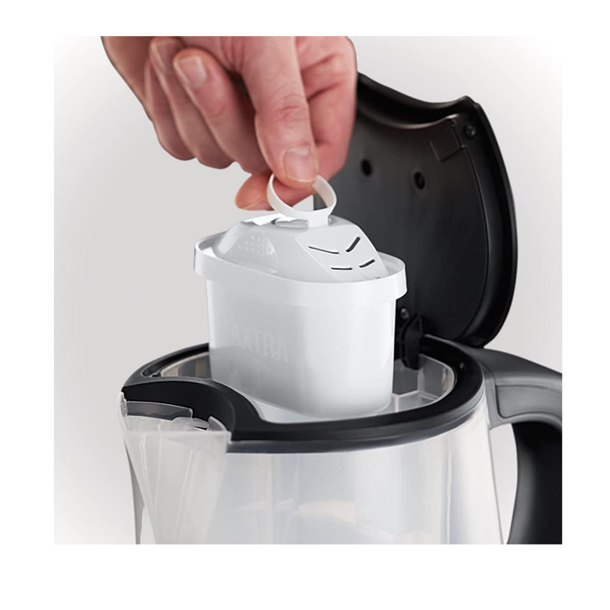 Eine Hand, die einen weißen Wasserfilter in einen transparenten Wasserfilterbehälter legt.