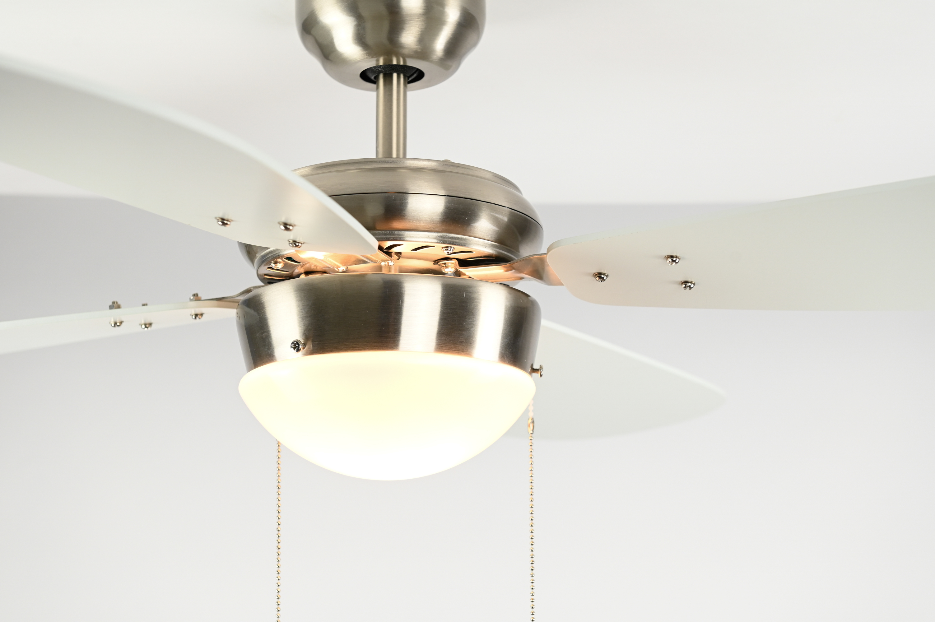 Deckenventilator mit weißen Flügeln und einer Leuchte, vor weißem Hintergrund.