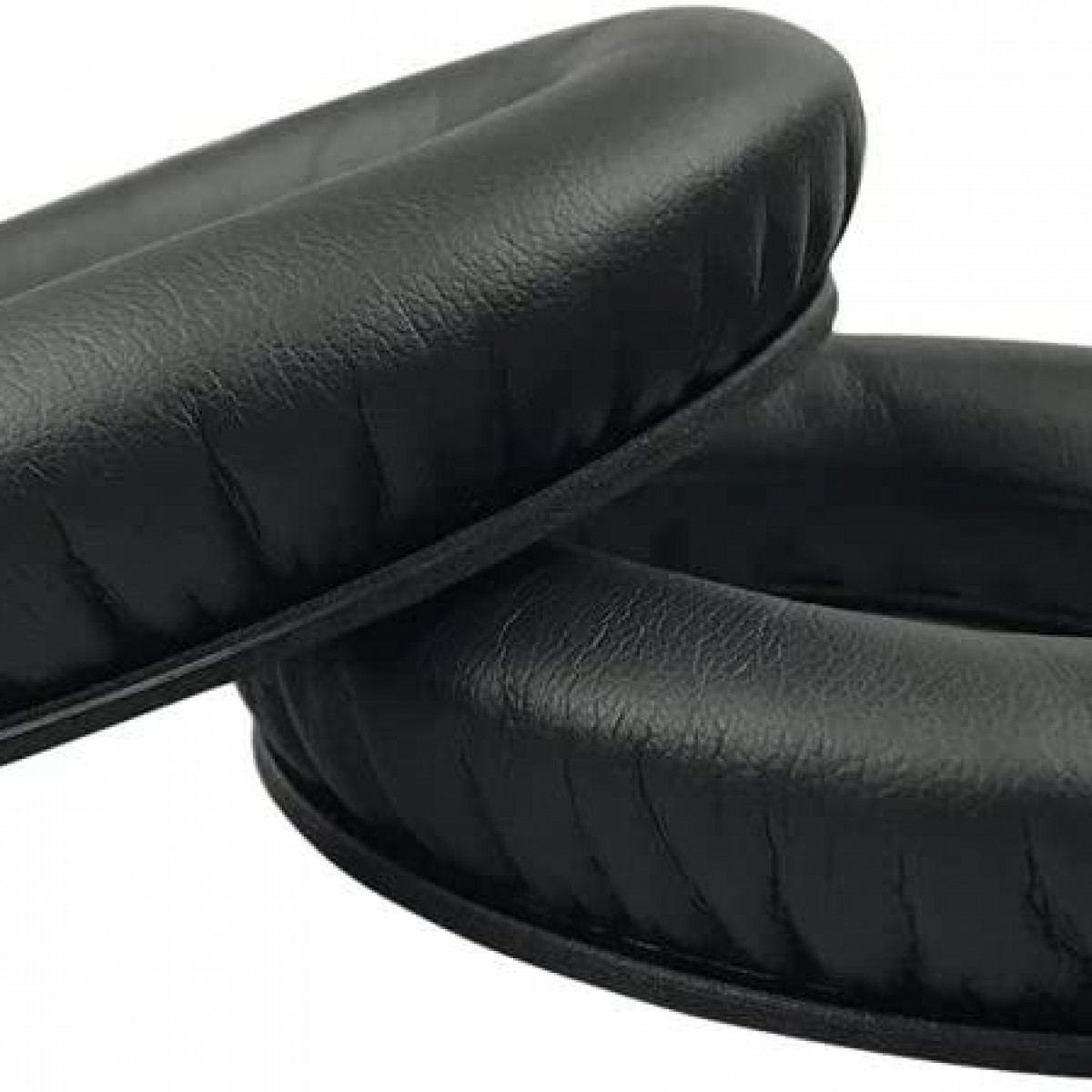 Zbliżenie dwóch czarnych nauszników do słuchawek. Poduszki są okrągłe i wykonane ze skóry.