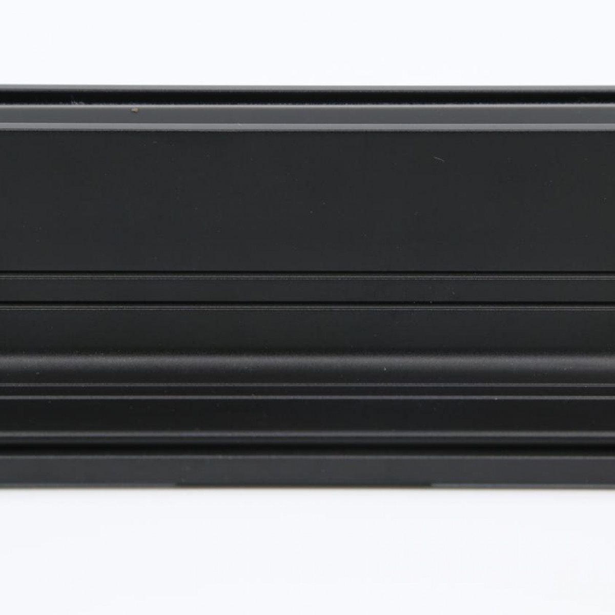 Schwarze, geriffelte architektonische Leiste mit glatter Oberseite und mehreren horizontalen Linien.