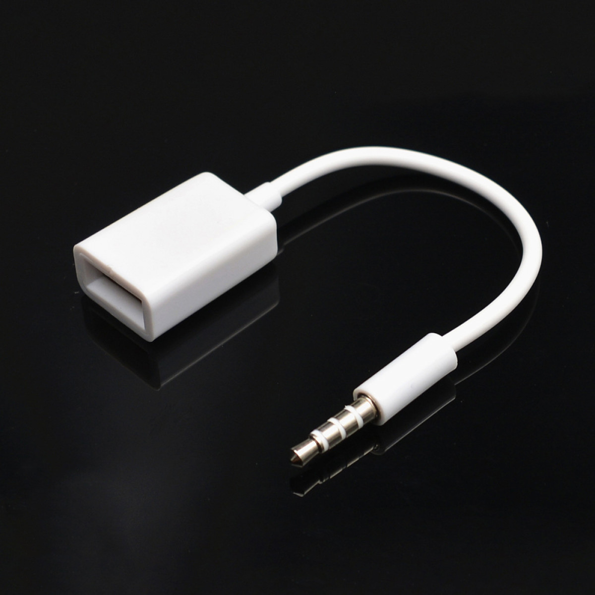 Ein weißes USB-zu-3,5-mm-Audioadapterkabel auf einer schwarzen, reflektierenden Oberfläche.