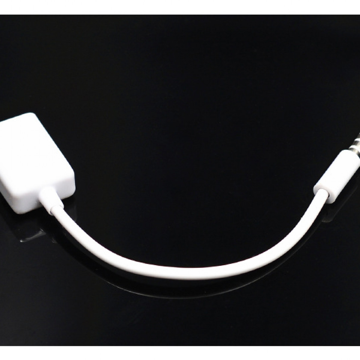 Ein weißer Adapter mit einem weißen Draht und einem schwarzen Hintergrund. Der Adapter hat einen kleinen Stecker.