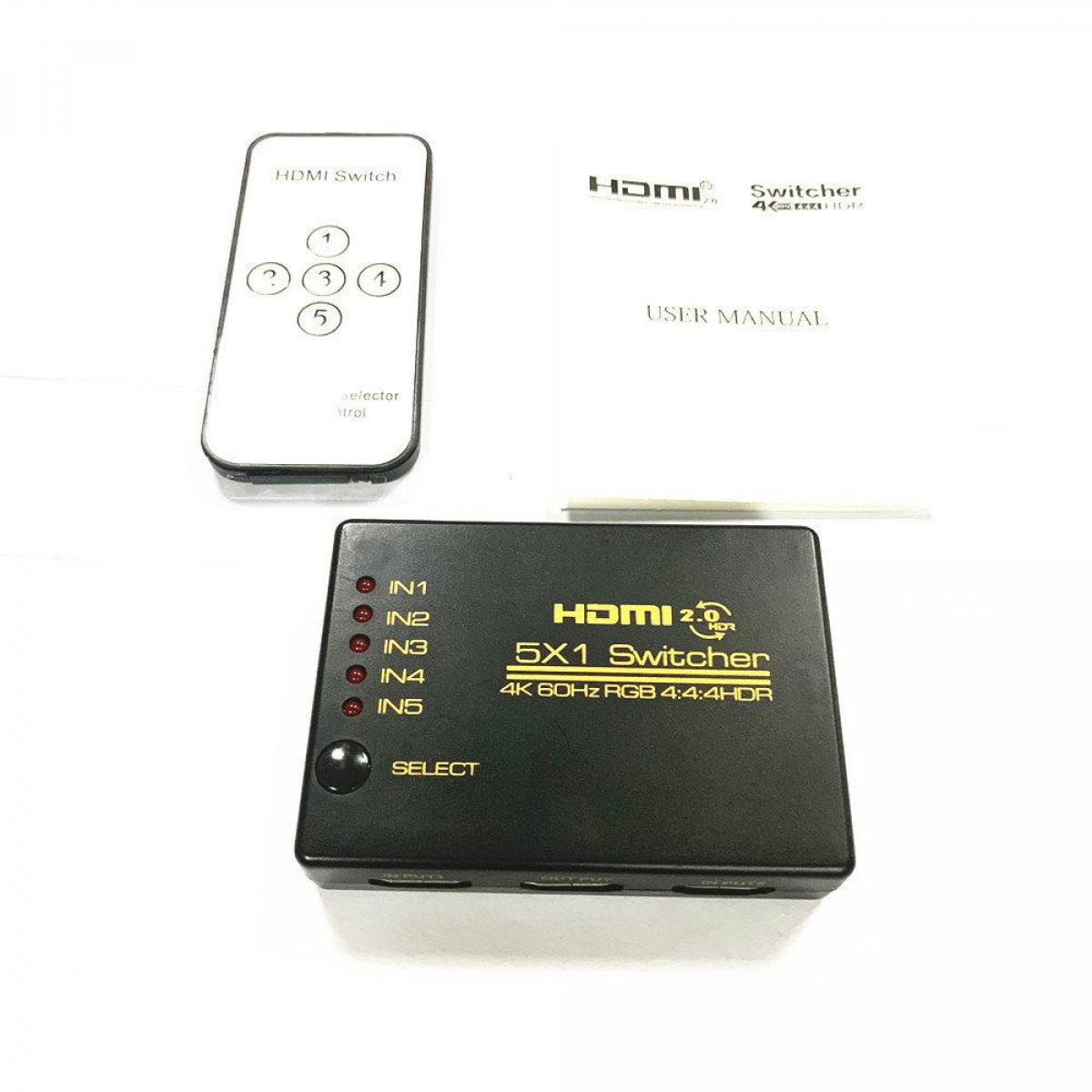 HDMI-Switch und Fernbedienung mit Bedienungsanleitung. Der HDMI-Switch hat fünf Eingänge.