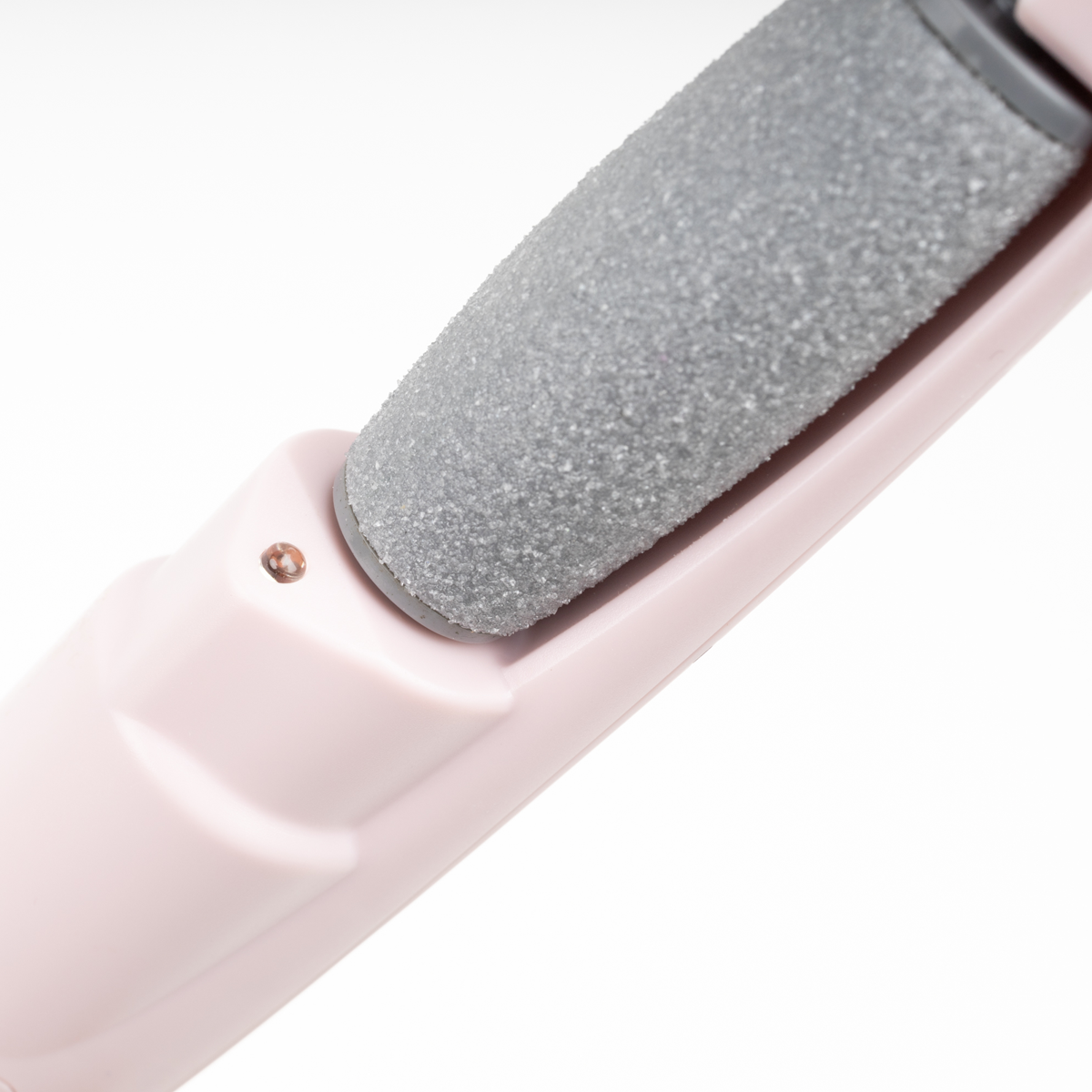 Primo piano di una lima per piedi rosa, con un rullo abrasivo grigio.