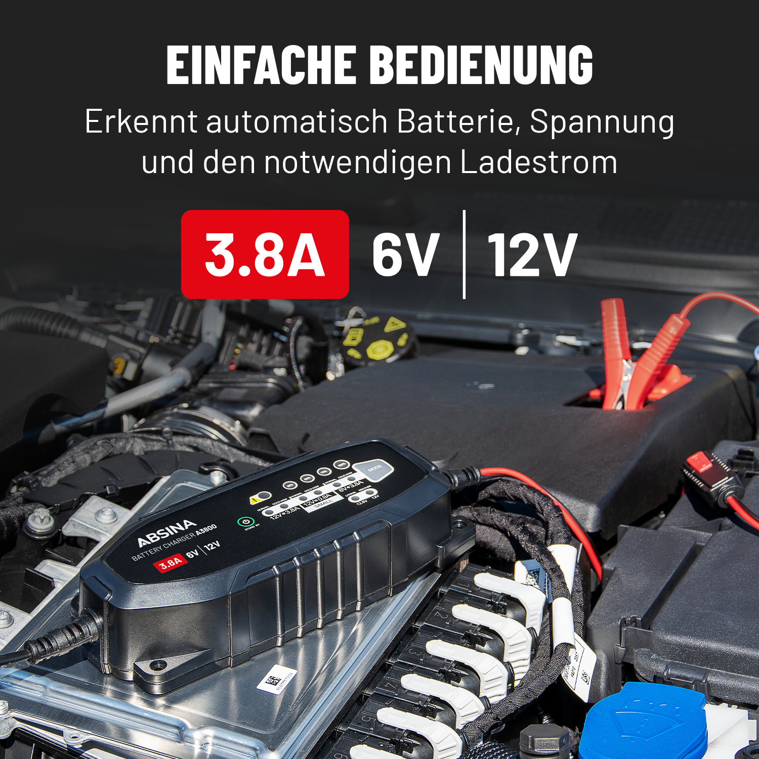 Kfz-Batterieladegerät. Text: 3,8A 6V 12V. Batterieladung mit angeschlossenen Klemmen im Motorraum.