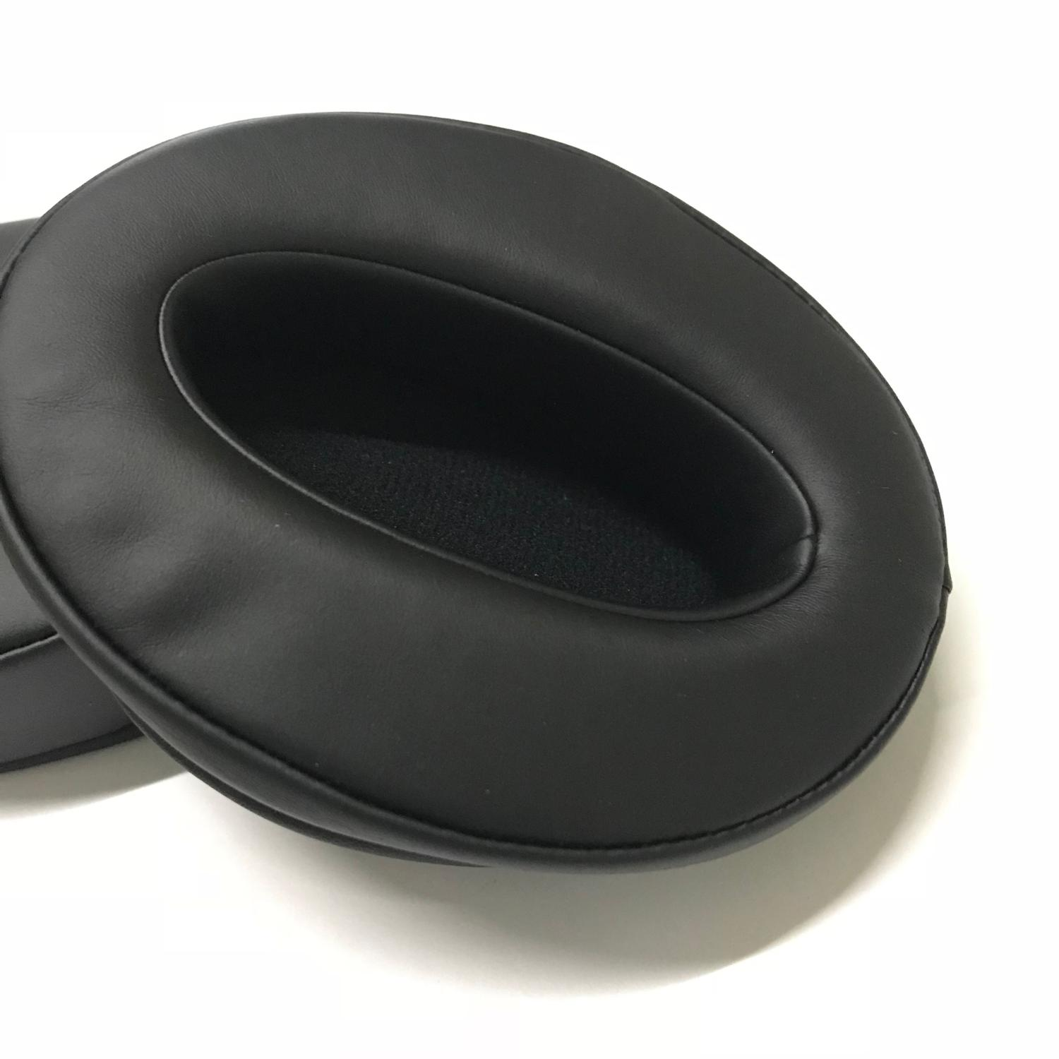 Zbliżenie dwóch czarnych nauszników na białej powierzchni.