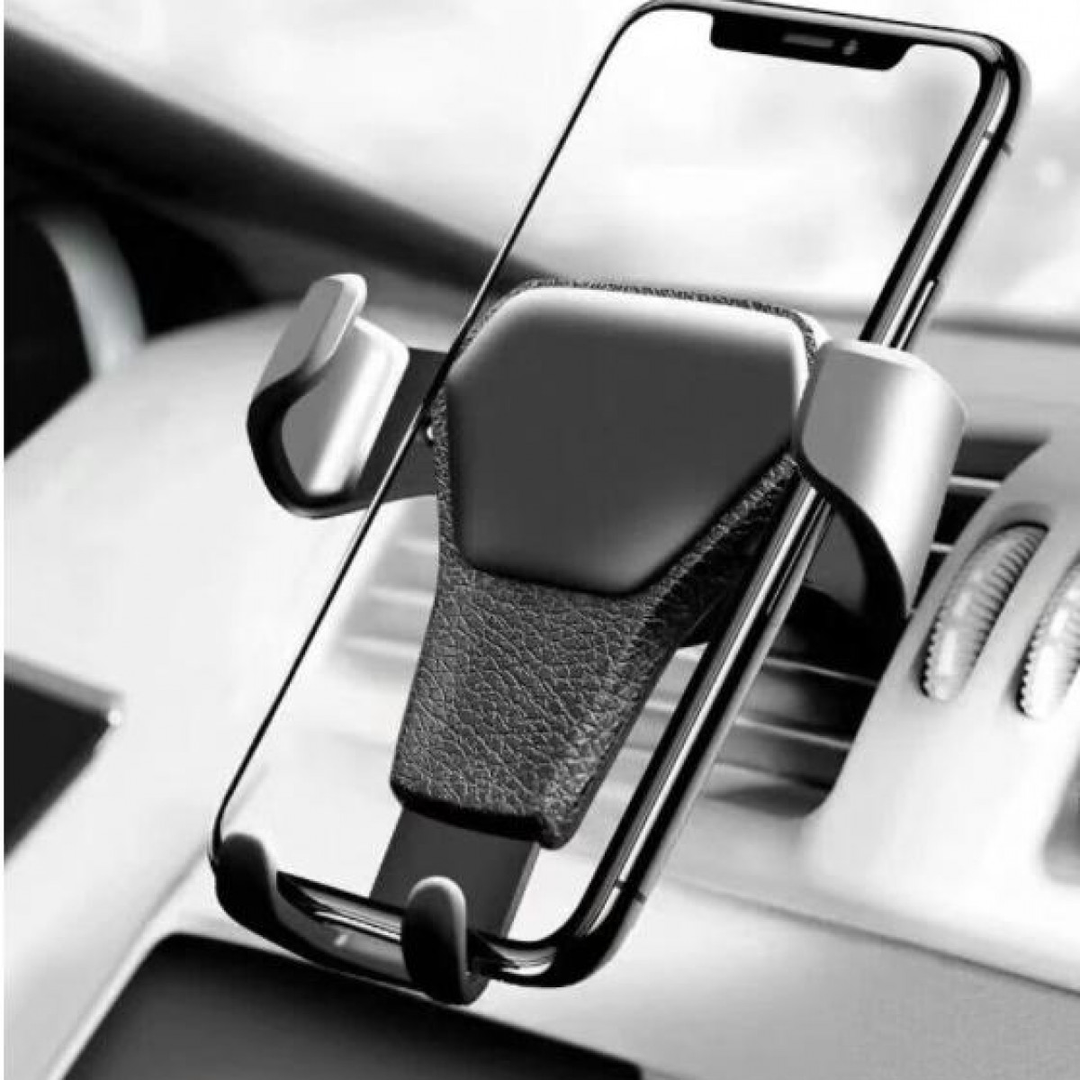 Een telefoon is vastgezet in een telefoonhouder voor in de auto, gemonteerd op een dashboard. De houder is zwart.