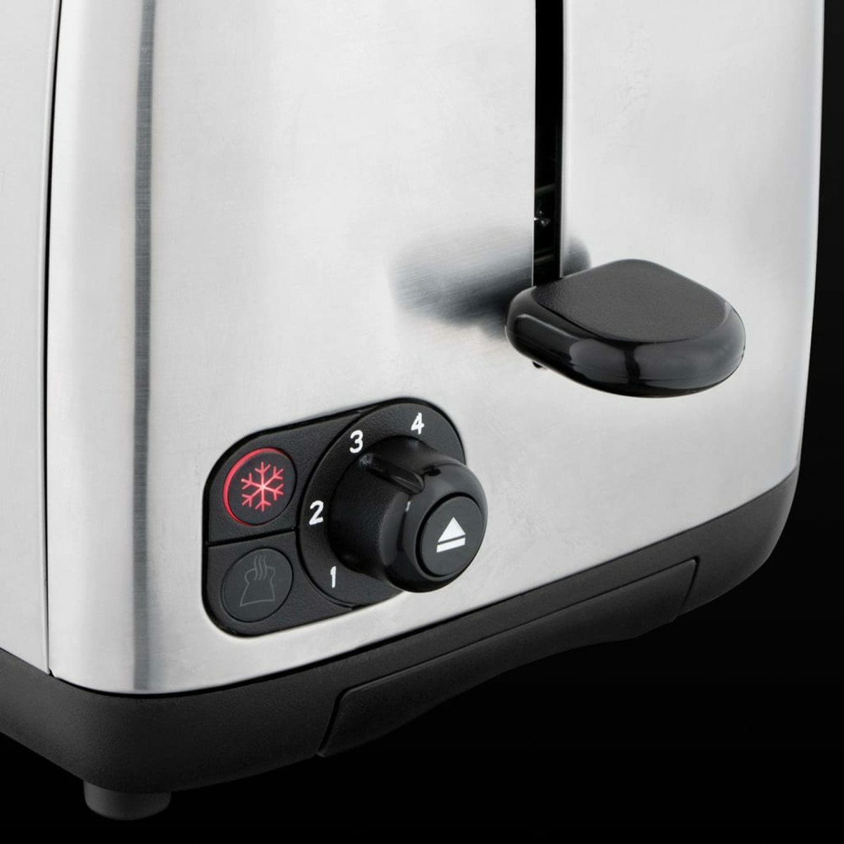 Zbliżenie srebrno-czarnego tostera z pokrętłem i przyciskami.