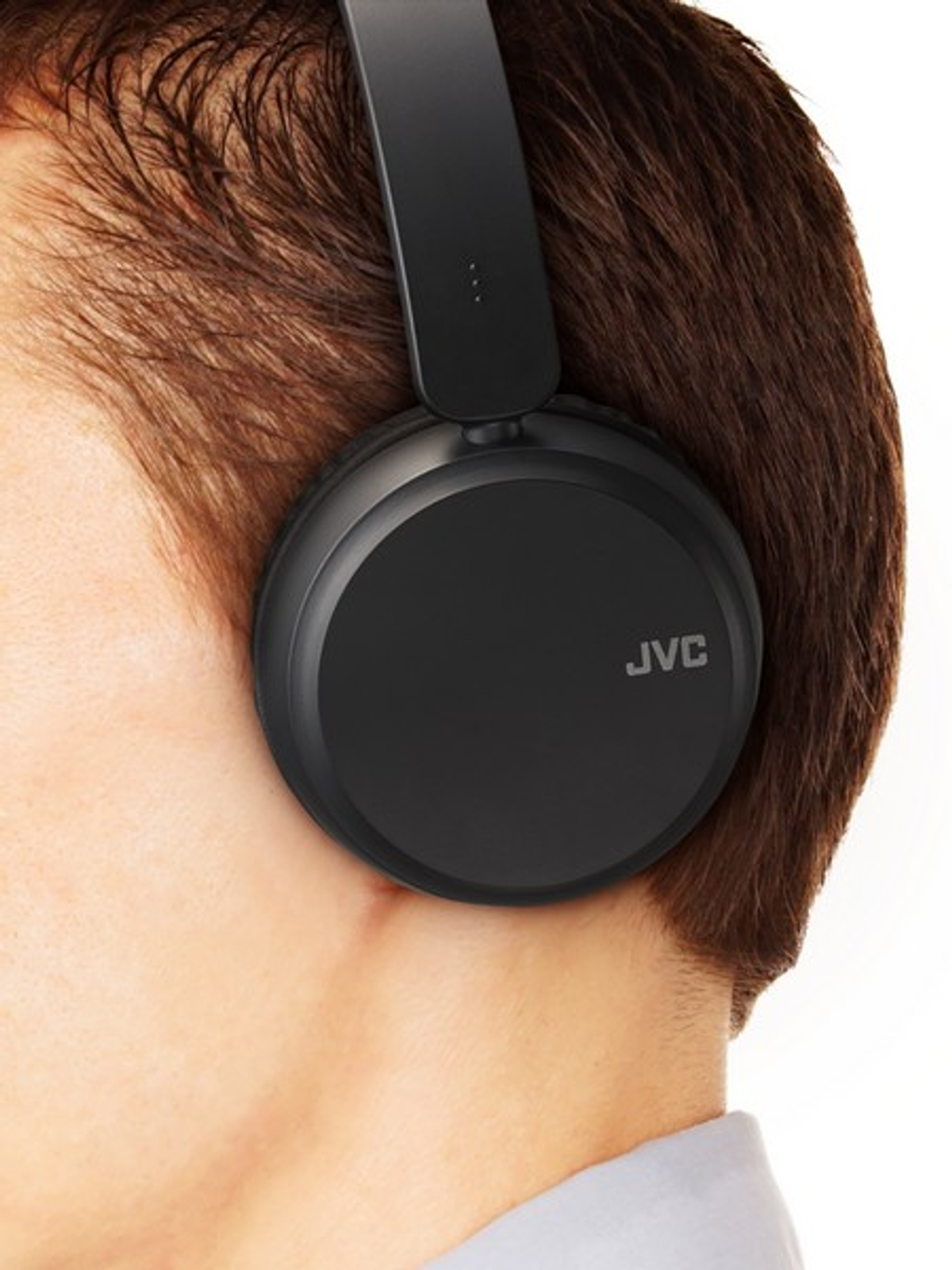Ein Mann trägt schwarze JVC-Kopfhörer mit dem Logo.