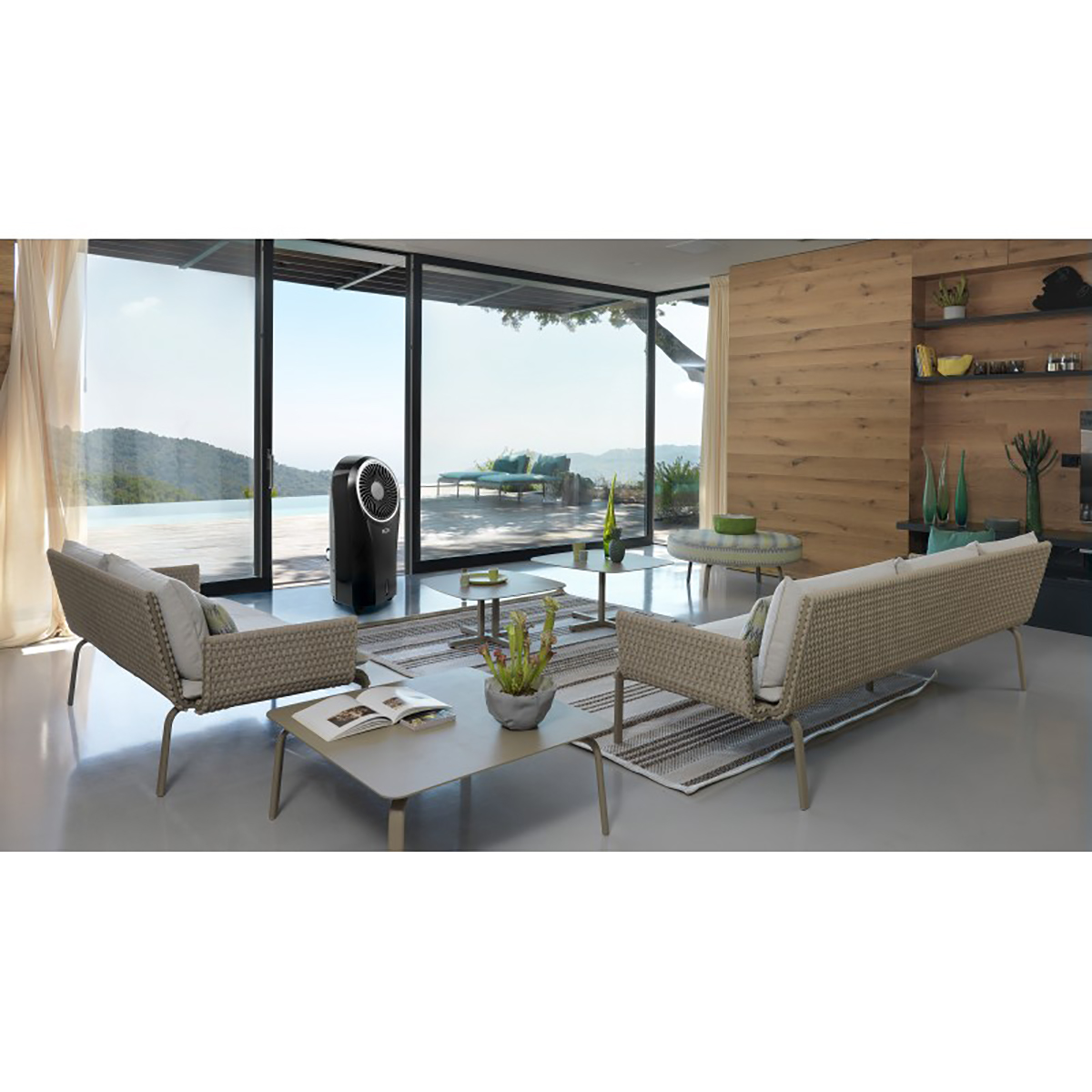 Un salón con grandes ventanales, muebles y un enfriador de aire.