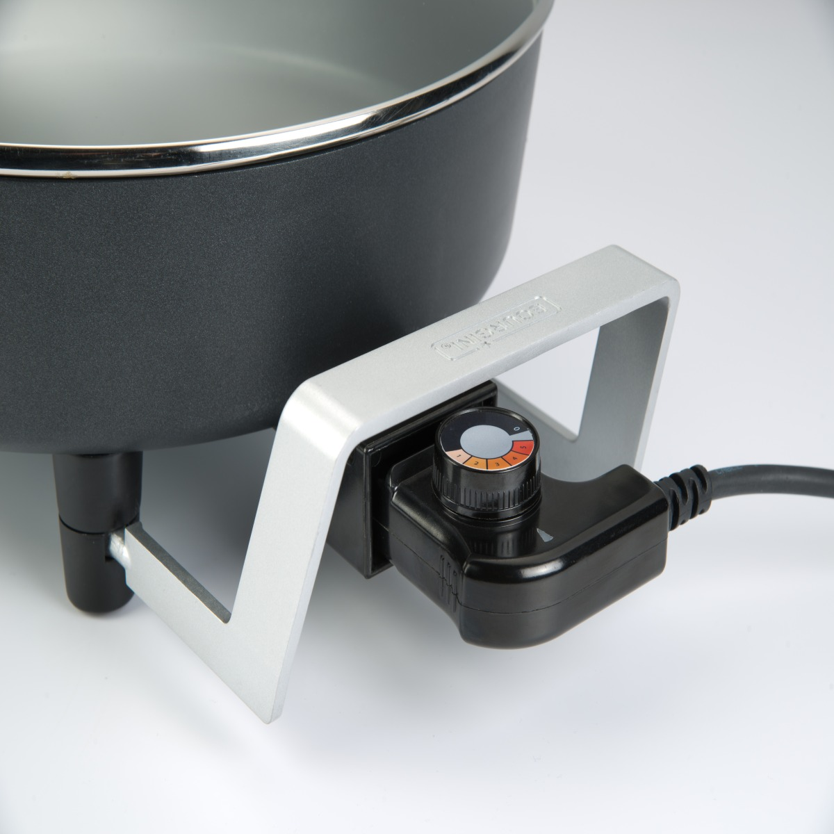 Sartén eléctrica negra con asa plateada y perilla de control de temperatura. Fondo blanco.