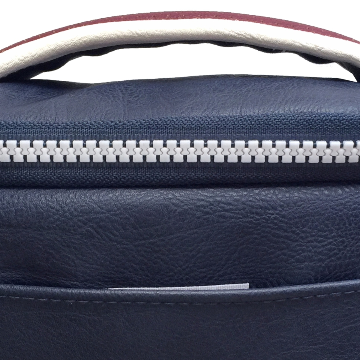 Primer plano de una bolsa azul oscuro con cremallera y asa blancas.