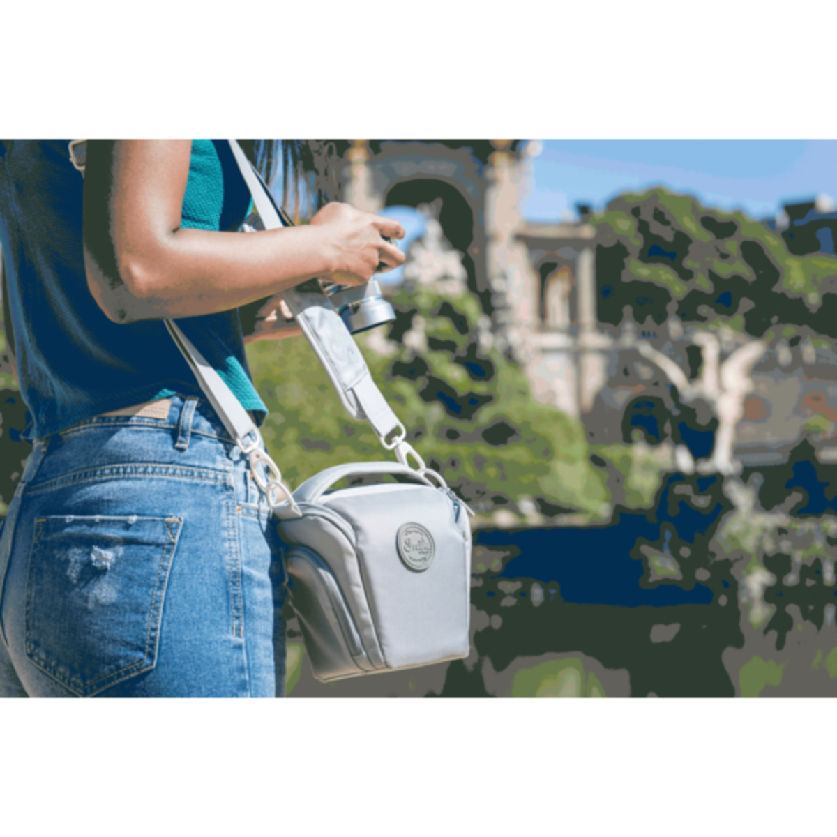 Una persona con una bolsa de cámara está tomando una foto frente a un edificio y un cielo azul.