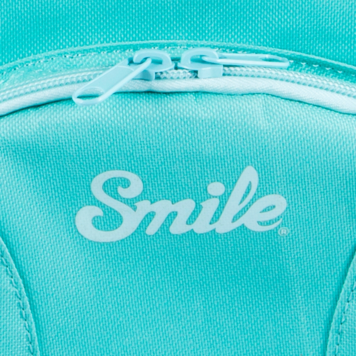 Primer plano de una mochila color turquesa con cremallera blanca y la palabra "Smile" en letras cursivas blancas.