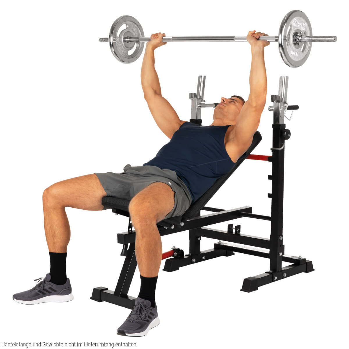 Mann liegt auf einer Bank und hebt eine Langhantel. Fitnessgeräte. Graue Shorts und Schuhe. Weißer Hintergrund.