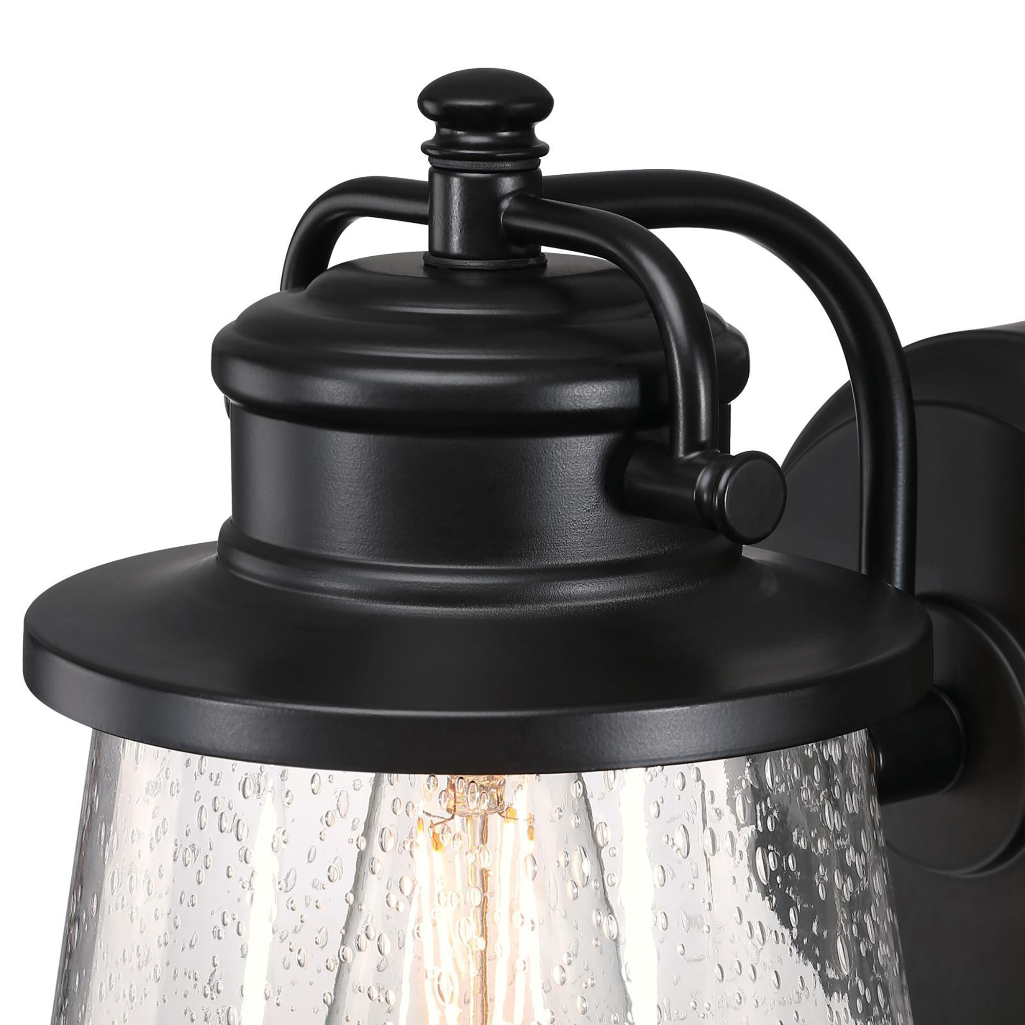 Nahaufnahme einer schwarzen Außenlampe mit Glasabdeckung, im Glas ist eine Glühbirne sichtbar.