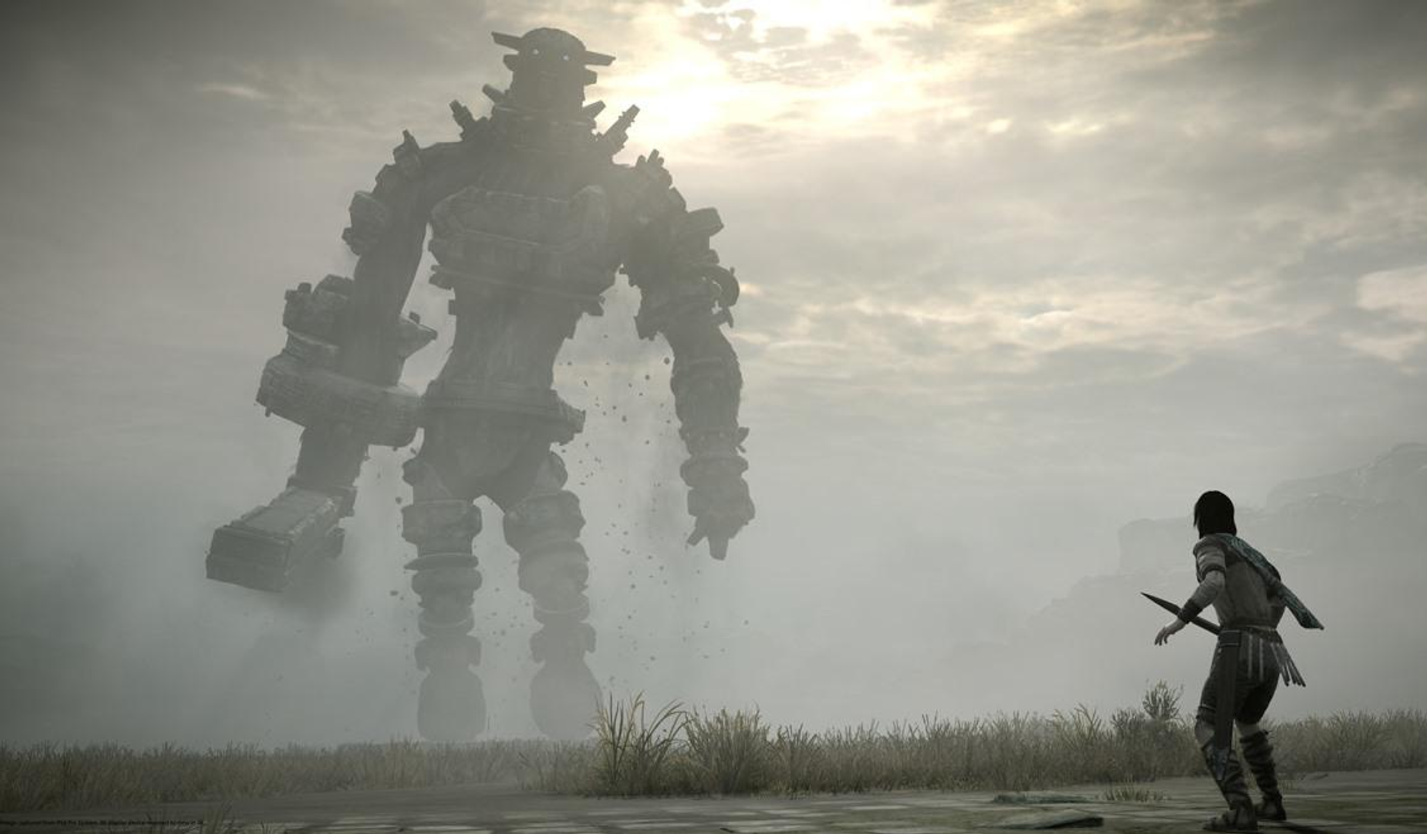 Un hombre se enfrenta a un monstruo gigante de piedra en un paisaje brumoso.