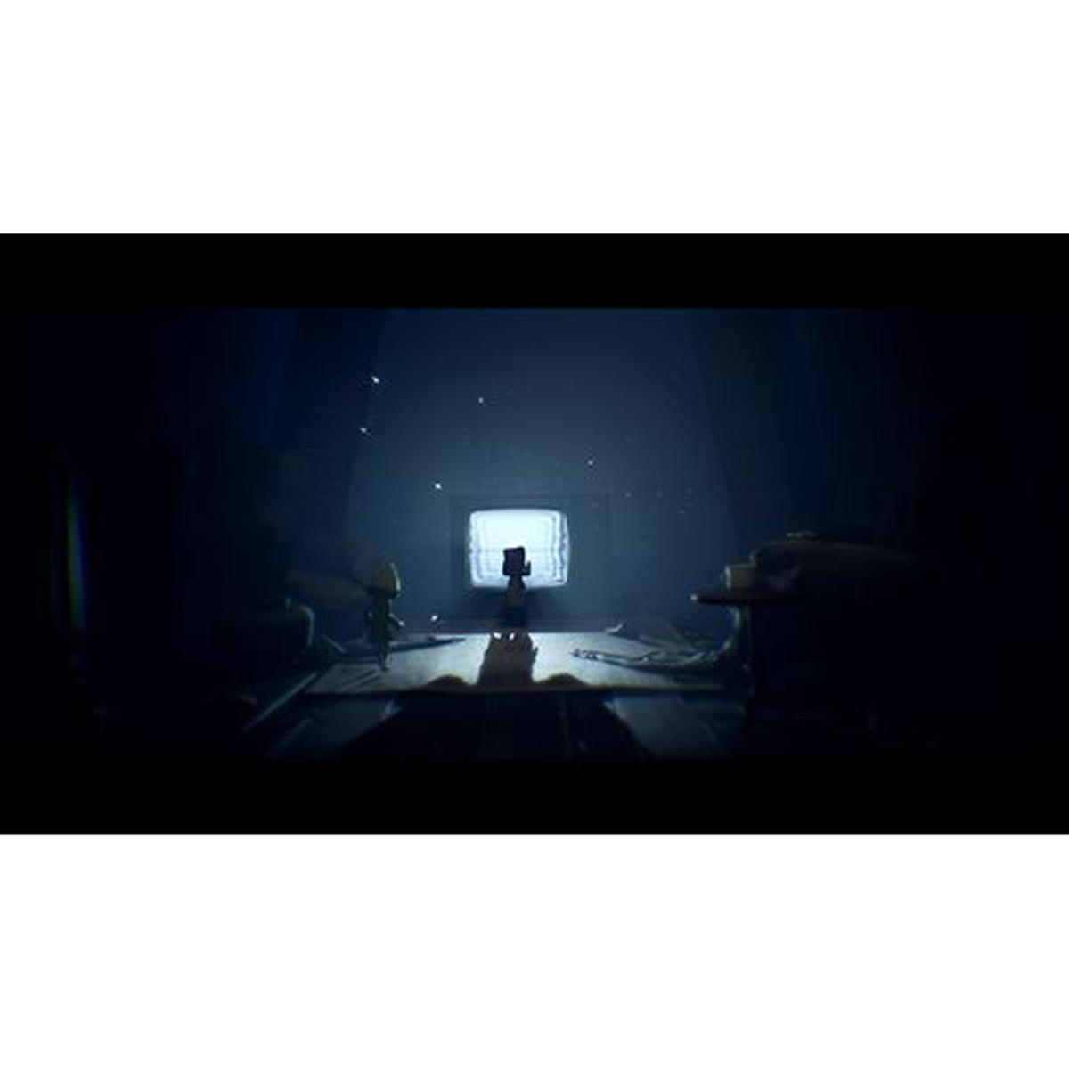 Una escena oscura de un videojuego. Un niño está frente a un televisor encendido. Sombras y oscuridad.