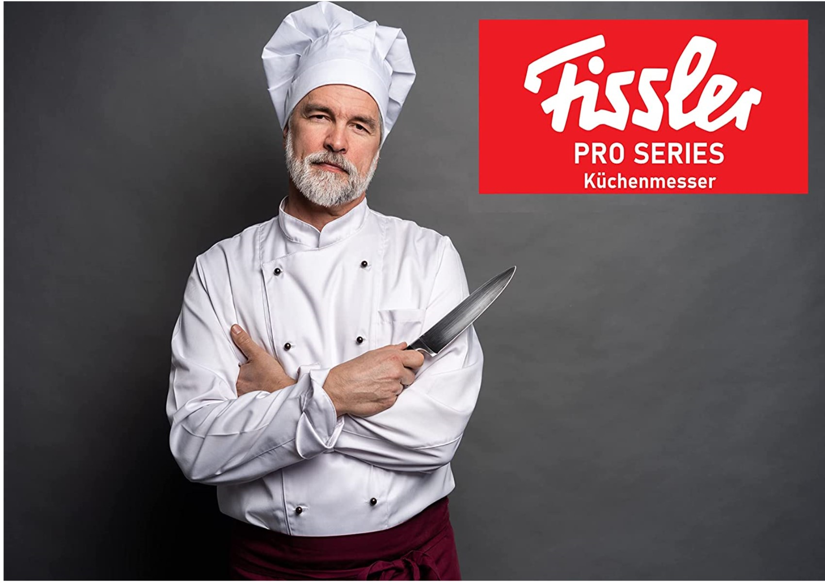 Koch in weißer Uniform hält ein Messer, mit Fissler-Logo im Hintergrund.