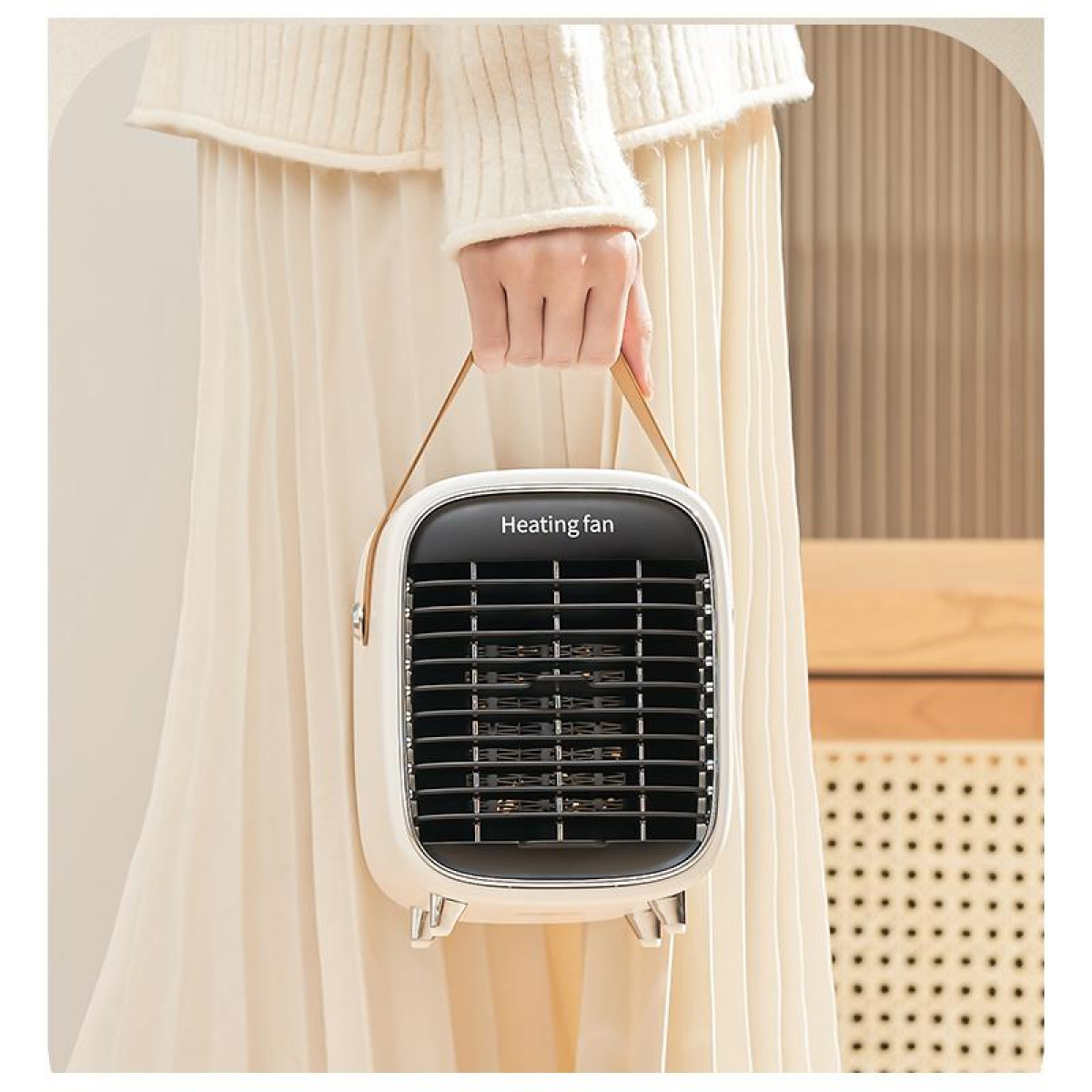 Biały wentylator grzewczy z uchwytem. Jest trzymany przez osobę w białej sukience.