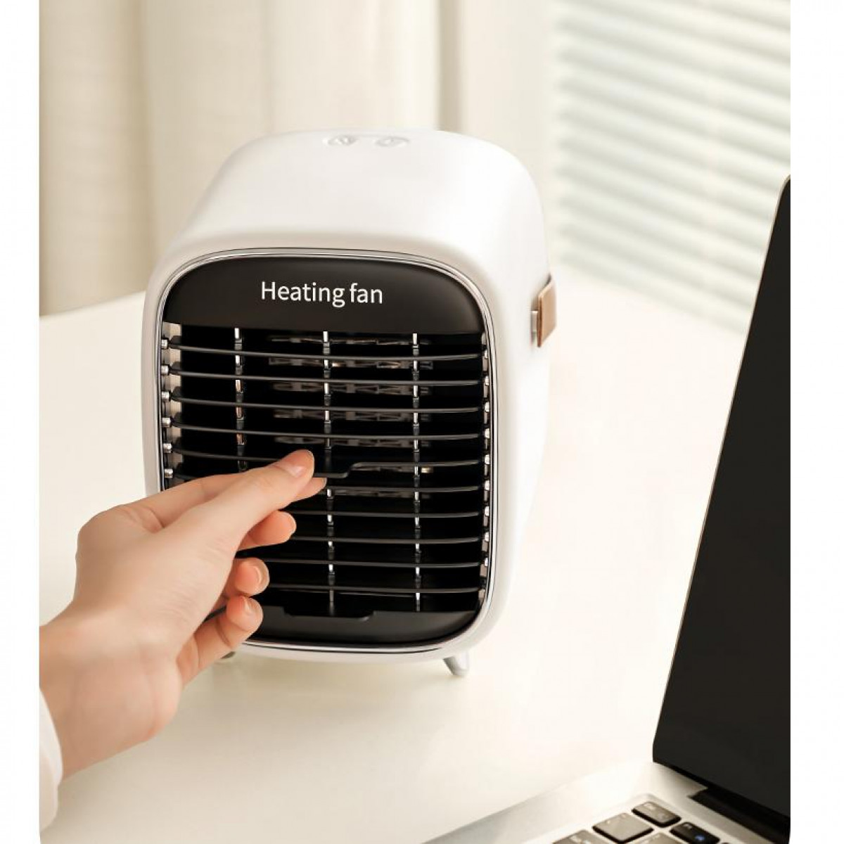 Biały wentylator grzewczy z ręką wskazującą na kratkę. Widoczne słowa 'Heating fan'.