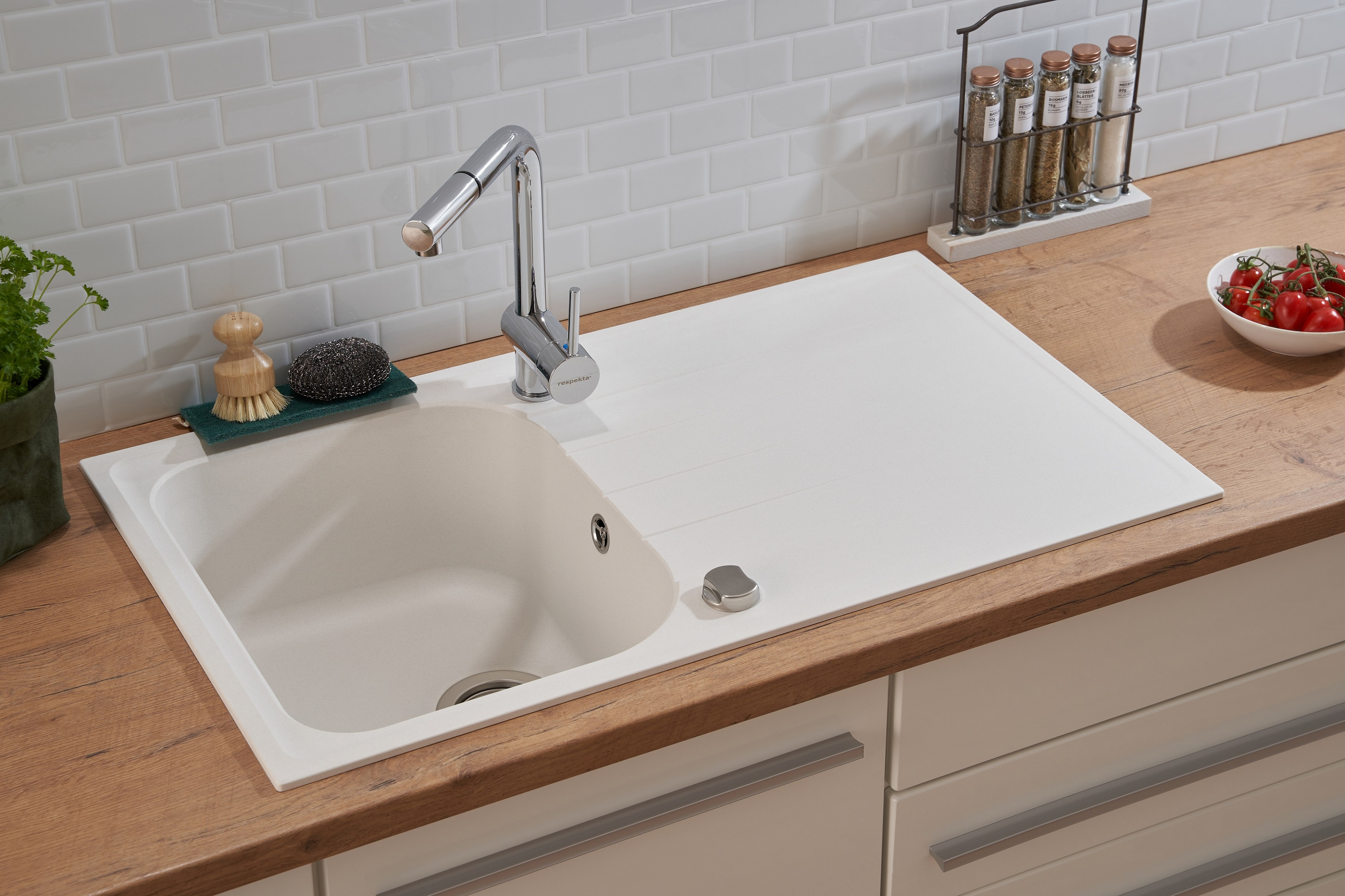Küchenspüle mit Wasserhahn, Seifenspender und Gewürzregal auf Holzplatte.