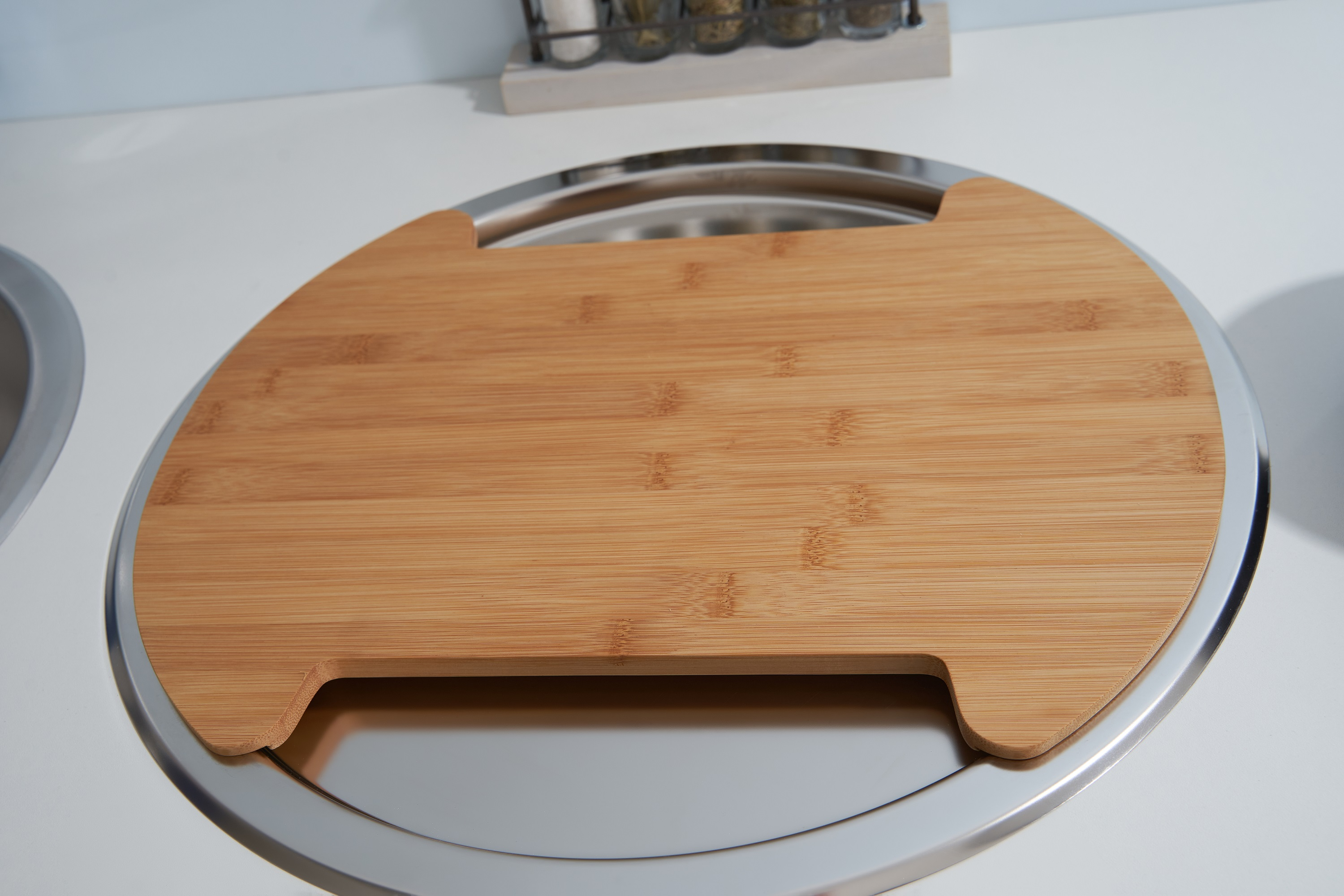 Holzschneidebrett in einem Metallbehälter. Das Schneidebrett hat einen Griff.