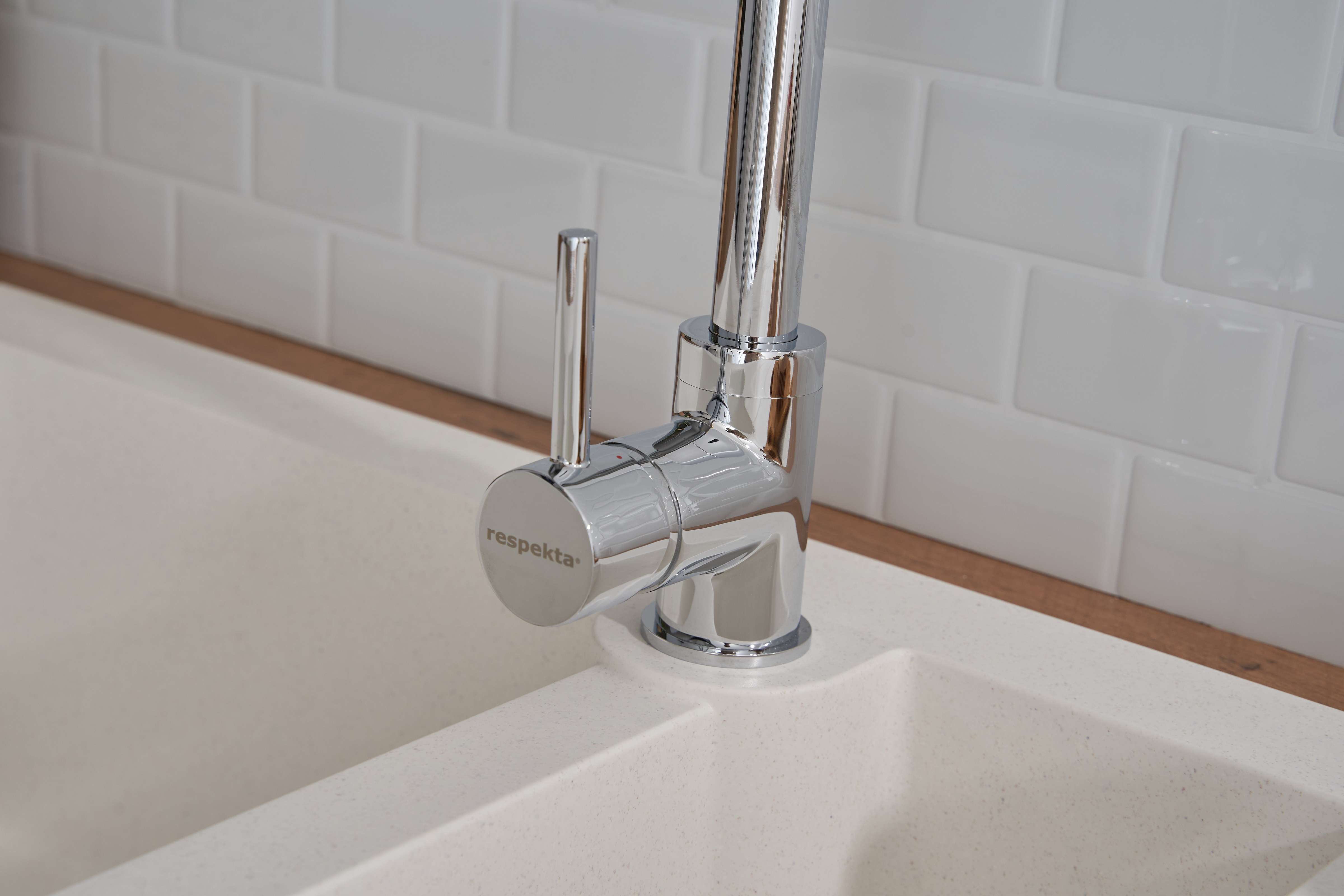 Ein Chrom-Wasserhahn mit gebogenem Auslauf und Hebelgriff in einem Waschbecken.