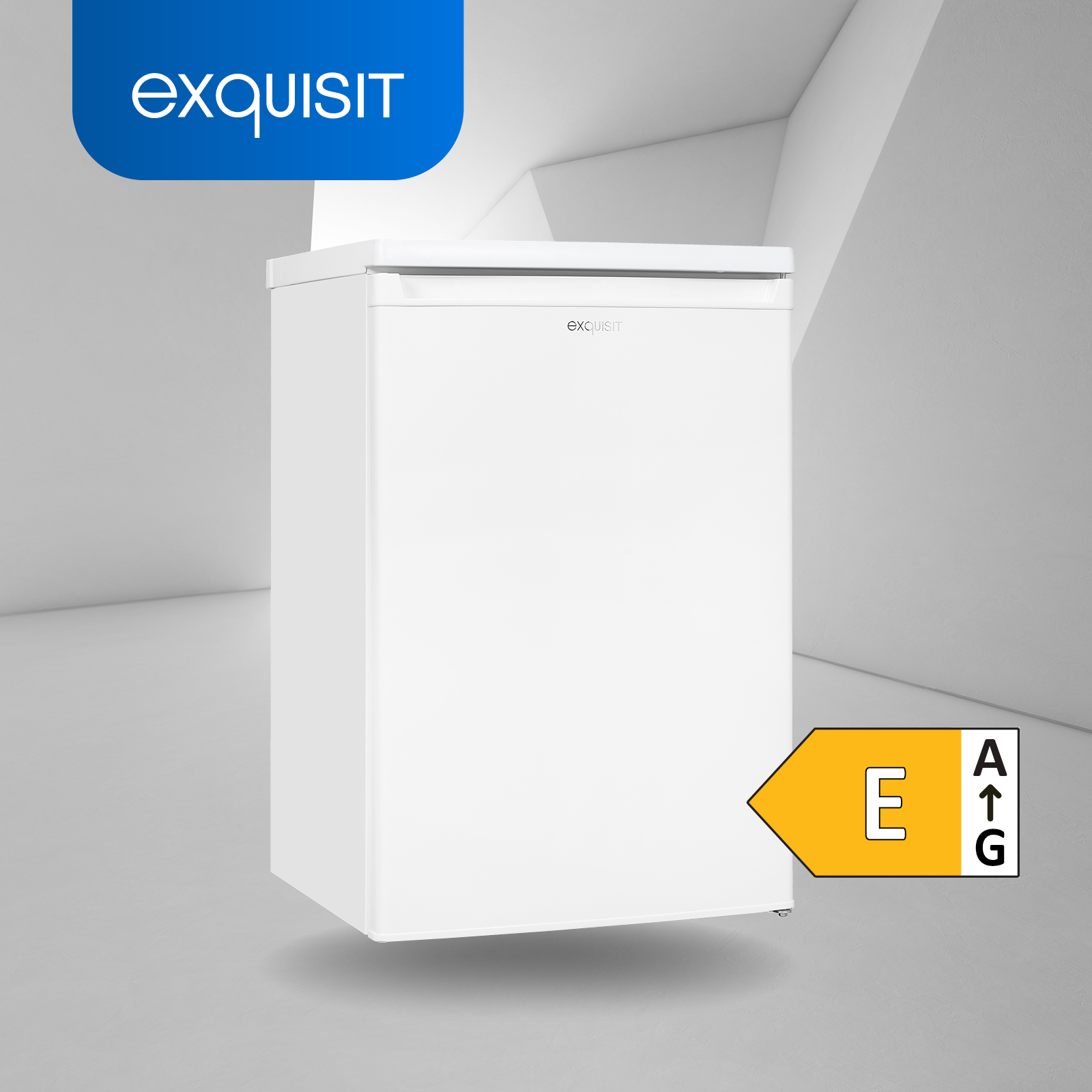 Ein weißer Exquisit-Kühlschrank mit einem Energielabel „E“. Er steht vor einem hellgrauen Hintergrund.