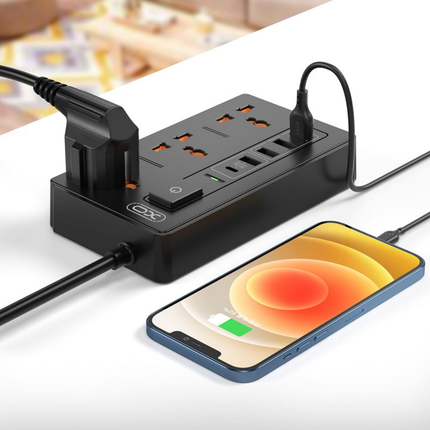 Schwarze Steckdosenleiste mit mehreren Steckdosen, USB-Anschlüssen und einem ladenden Telefon.