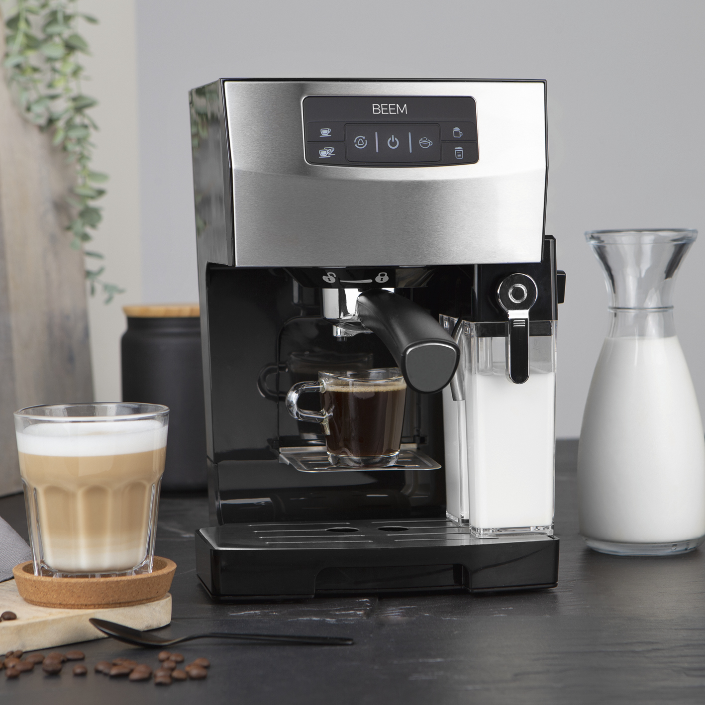 Espressomaschine aus Edelstahl mit Milchaufschäumer, Glas mit Kaffee.