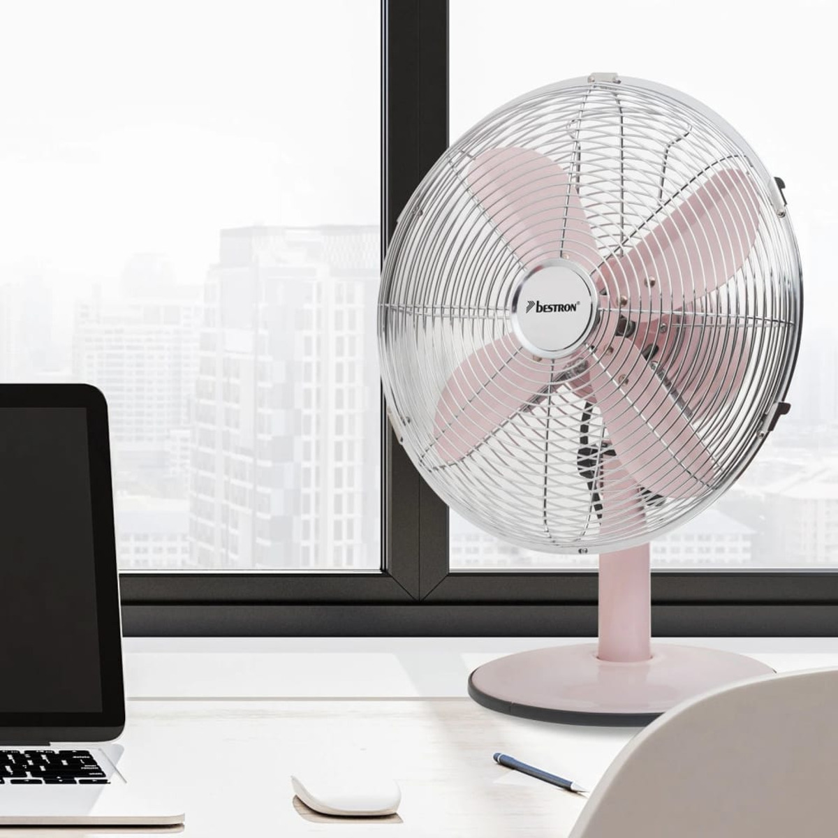 Ventilatore Bestron rosa e argento su una scrivania. Un laptop, un mouse e una finestra sono sullo sfondo.