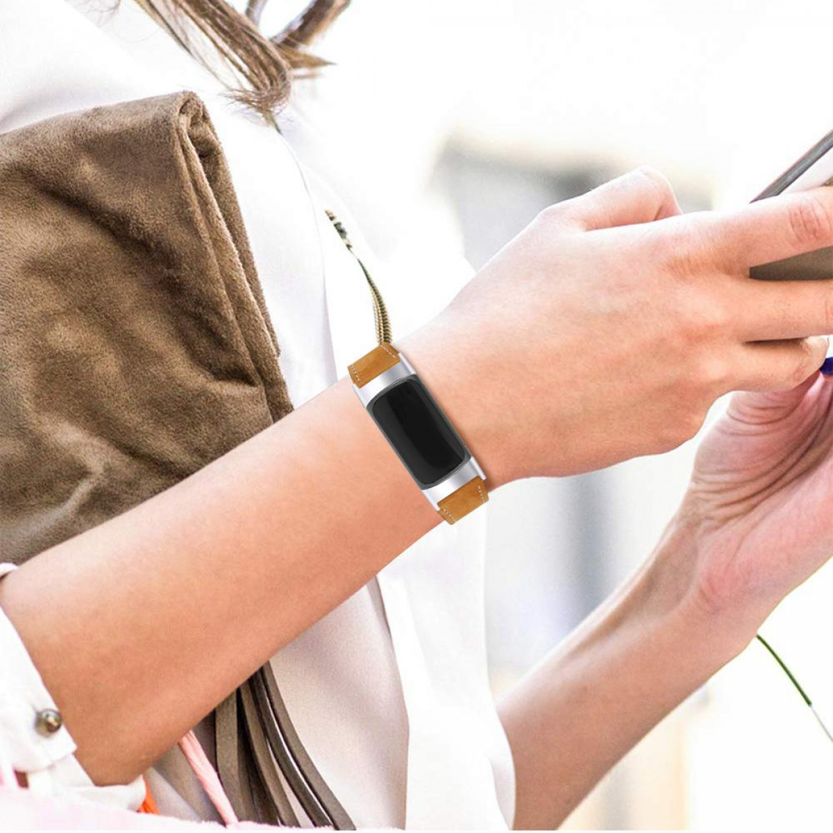 Persona che indossa uno smartwatch. L'orologio è al polso con un cinturino in pelle marrone.