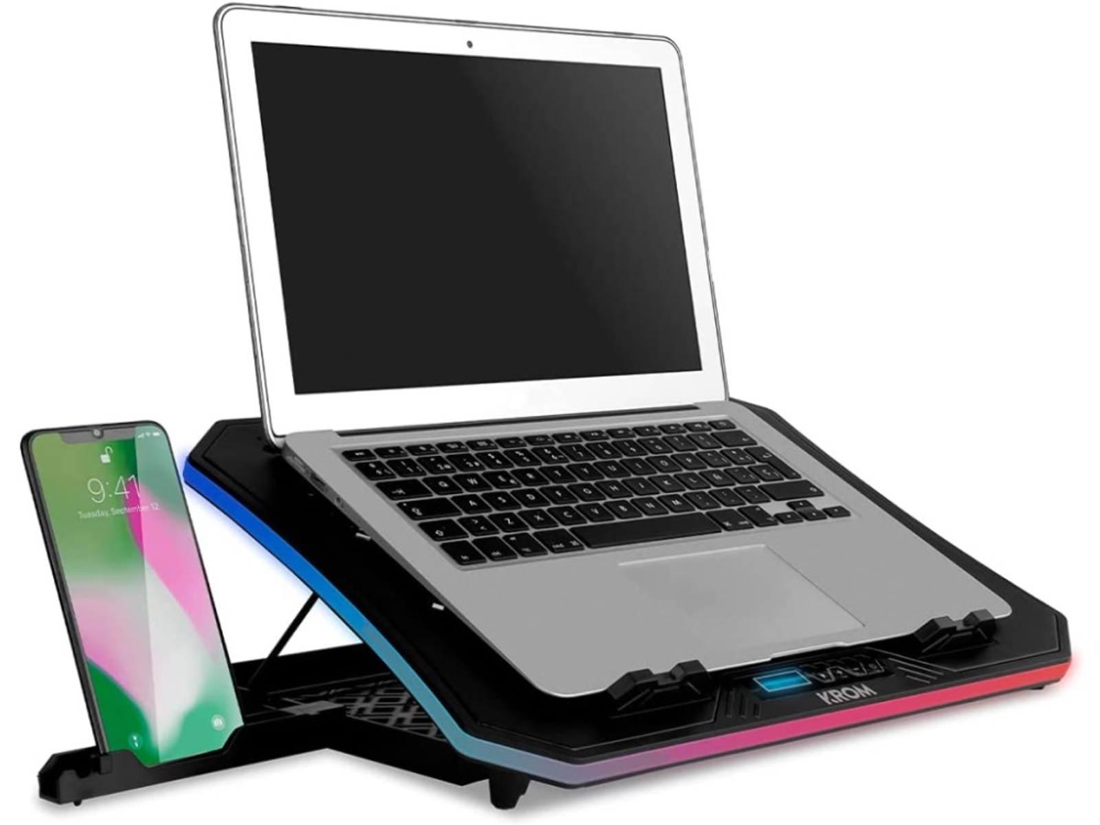 Laptop sobre soporte negro, con teléfono a la izquierda. El soporte tiene luces RGB.