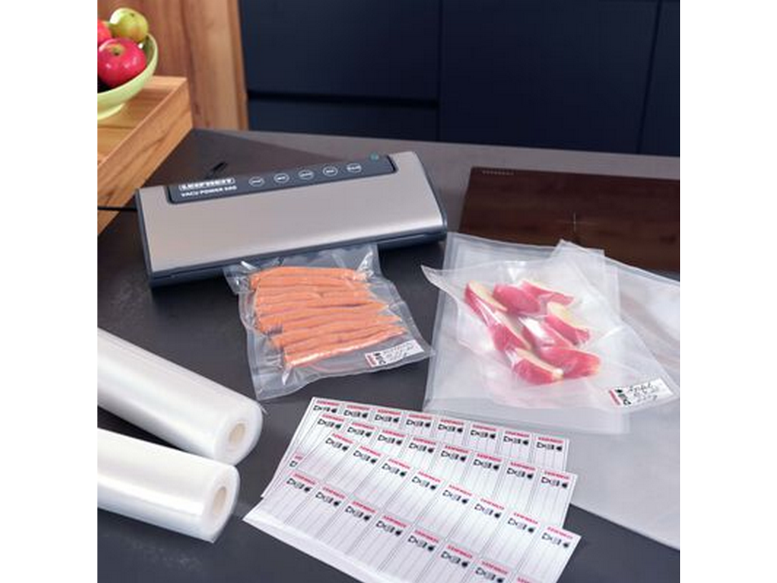 Sigillatrice sottovuoto con sacchetti ed etichette alimentari. Alcuni sacchetti contengono cibo.