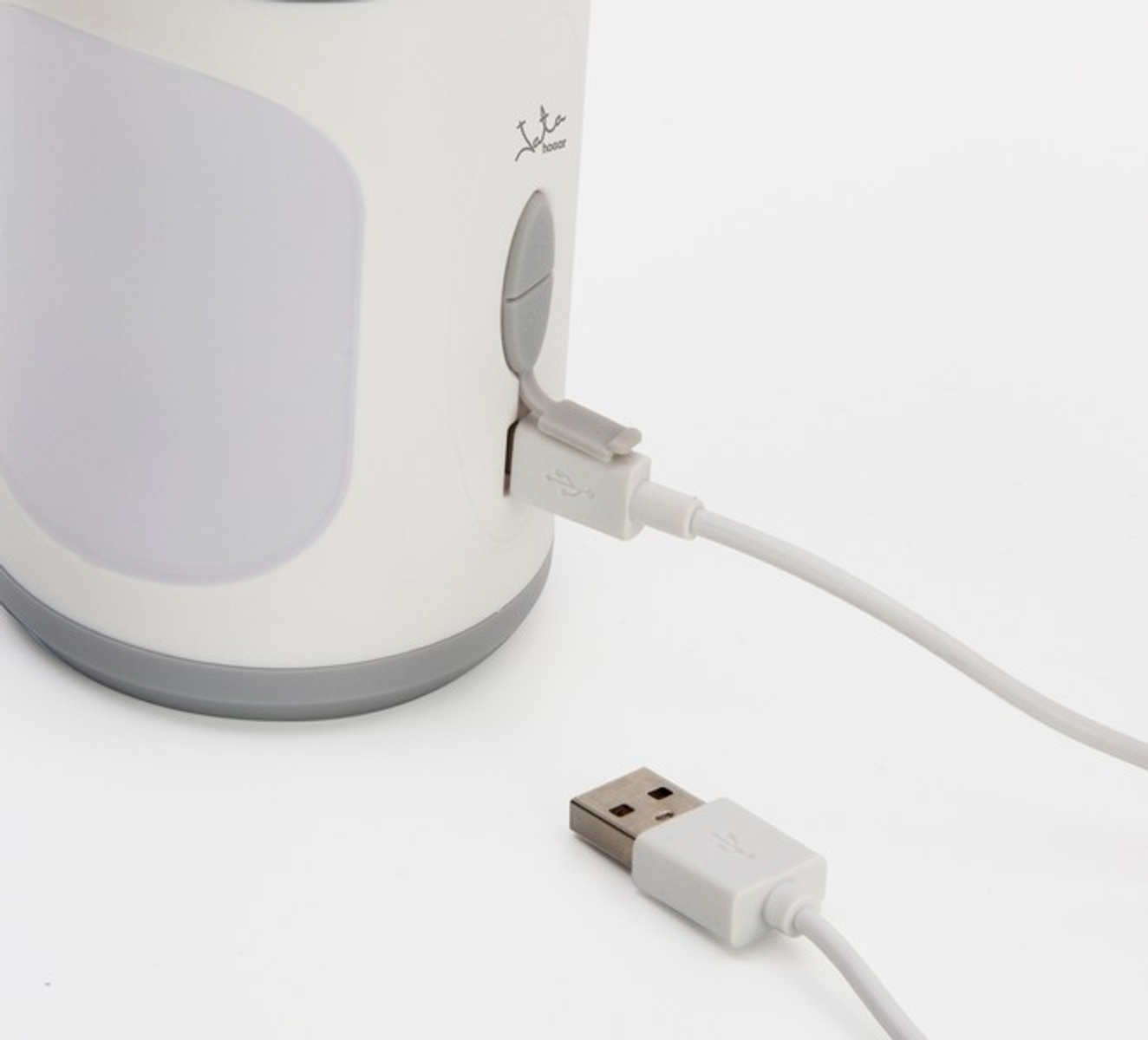 Lámpara blanca con cable USB enchufado. Un conector USB es visible.