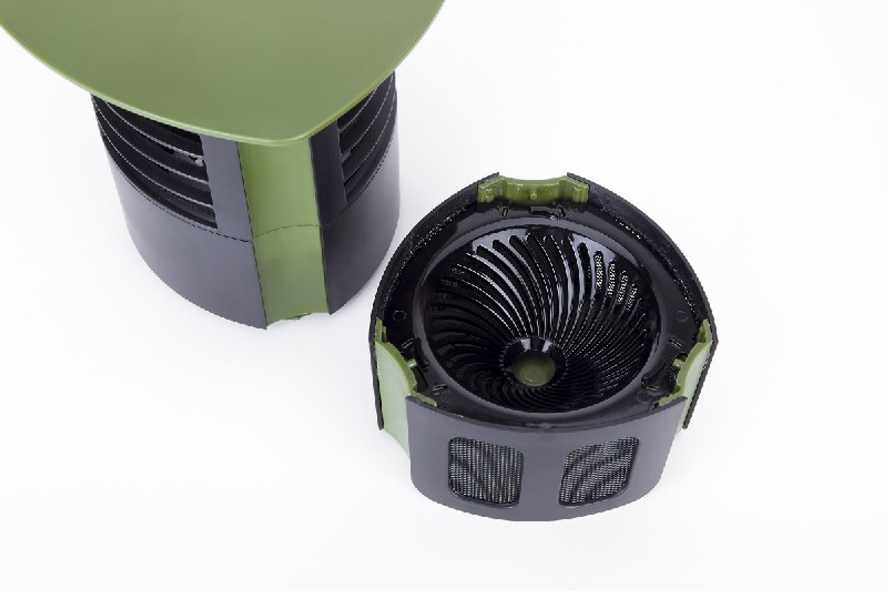 Partes de purificador de aire negro y verde, desmontadas, sobre blanco.